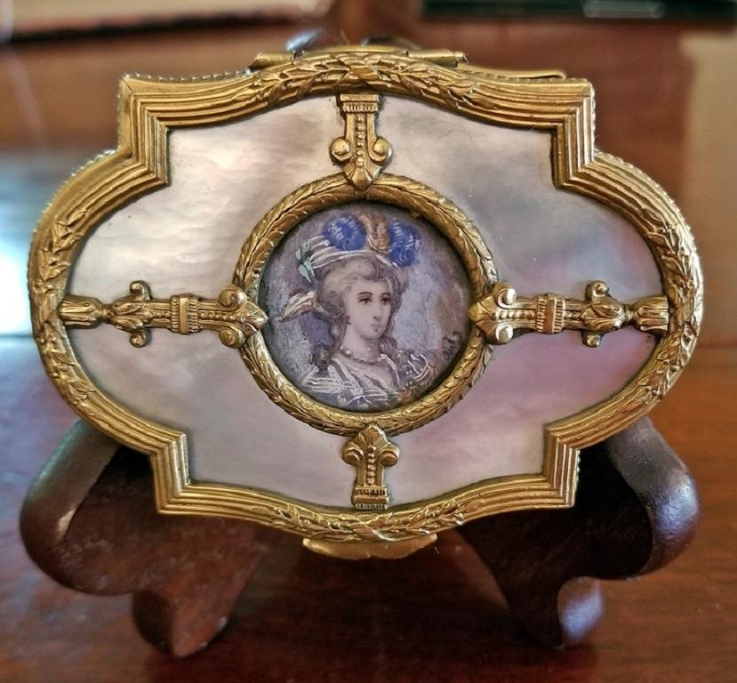 PRESENTING A STUNNING little French Ring Box from the 18th Century, namely a French Louis XVI Brass and MOP Box with Miniature Portrait of Lady.

Box inlaid with mother of Pearl and miniature portrait of a Lady of Importance, in period costume on