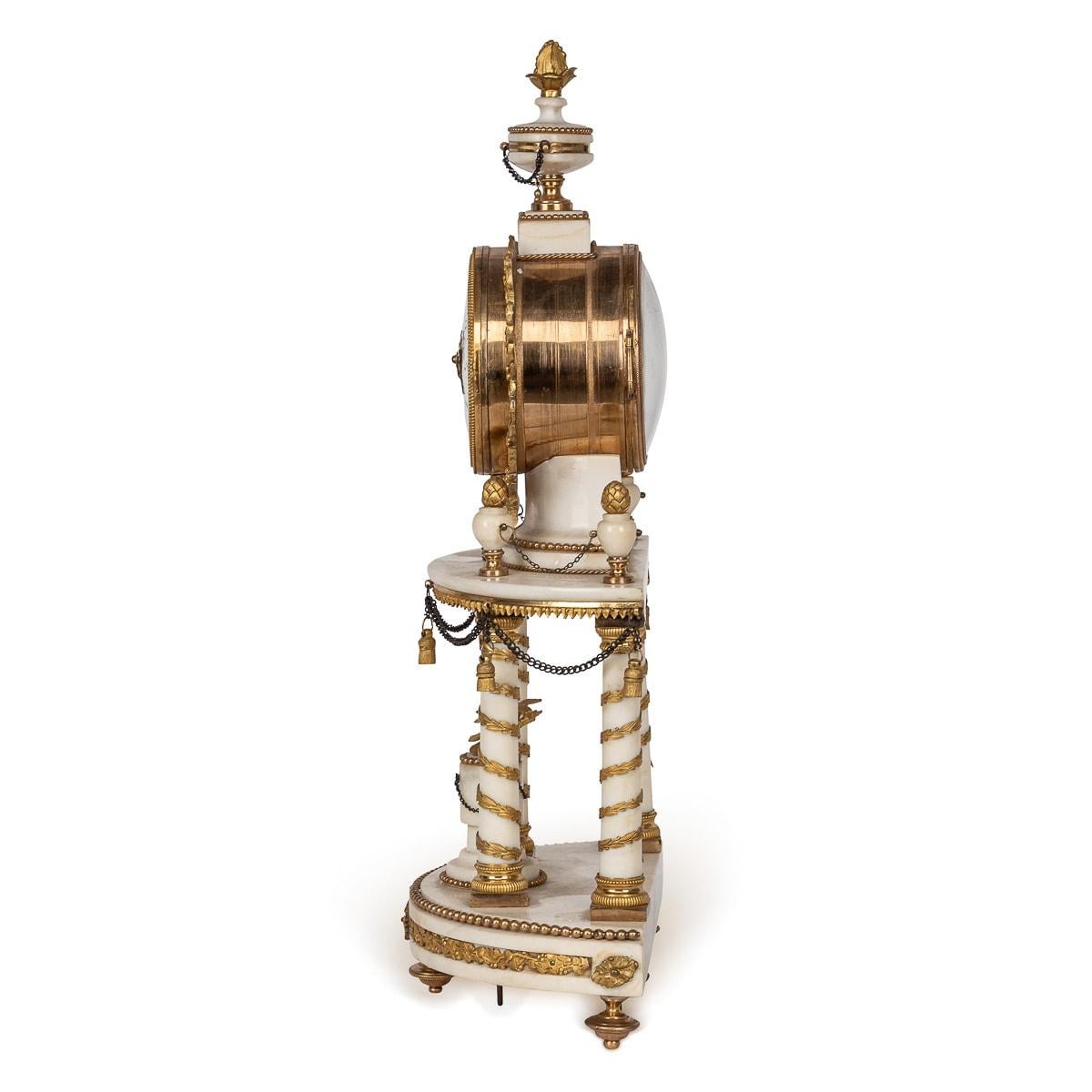 Pendule monumentale à portique du XVIIIe siècle signée par Charles Bertrand. Elle est de style classique Louis XVI, en marbre blanc monté avec des décorations en bronze doré. Le mouvement est maintenu en l'air par quatre piliers de marbre. Le sommet