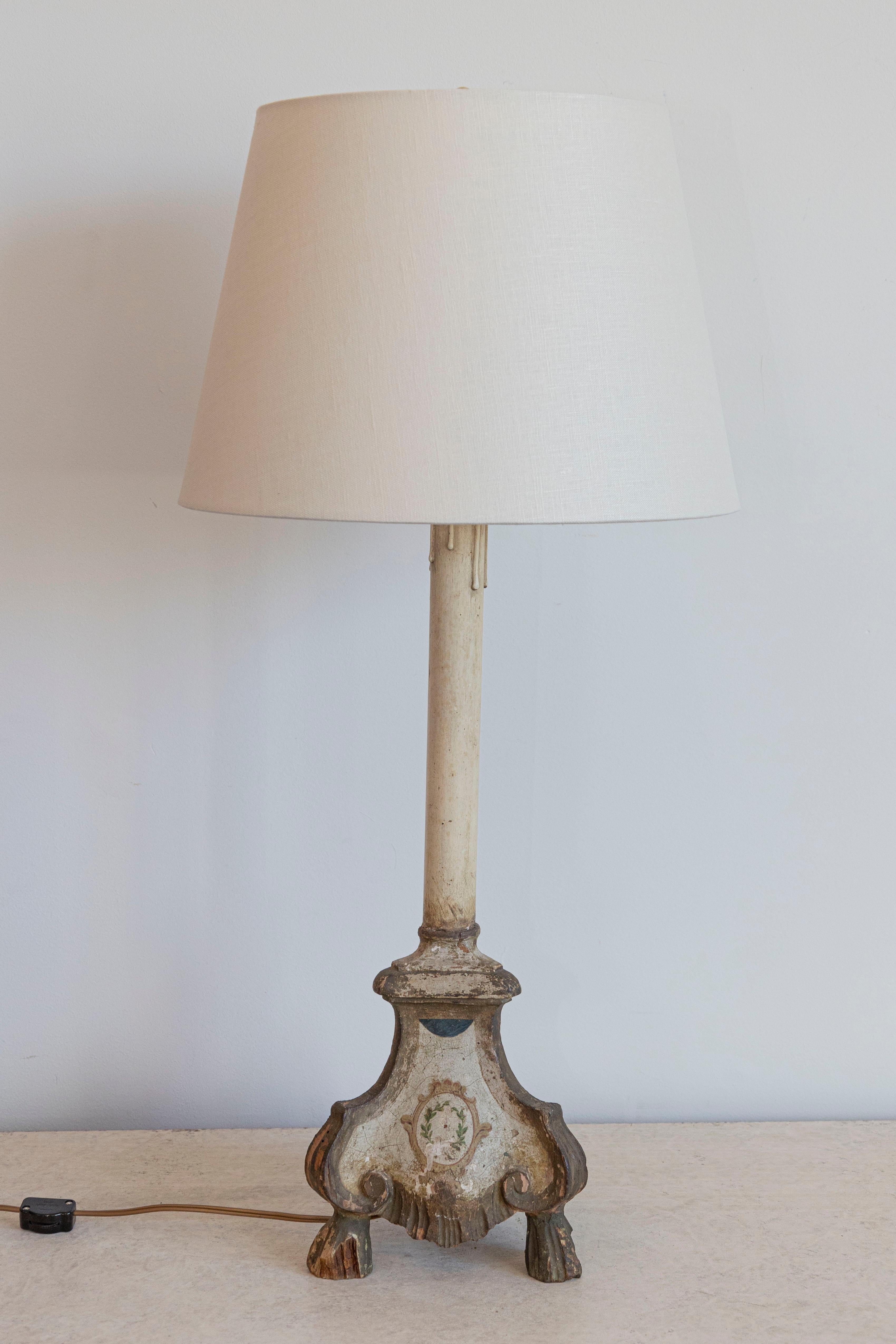Cette lampe de table française de style Louis XVI est fabriquée à partir d'un chandelier d'autel du XVIIIe siècle, reconverti en un remarquable objet d'éclairage. La base en bois sculpté à la main présente un design triforme avec d'élégantes
