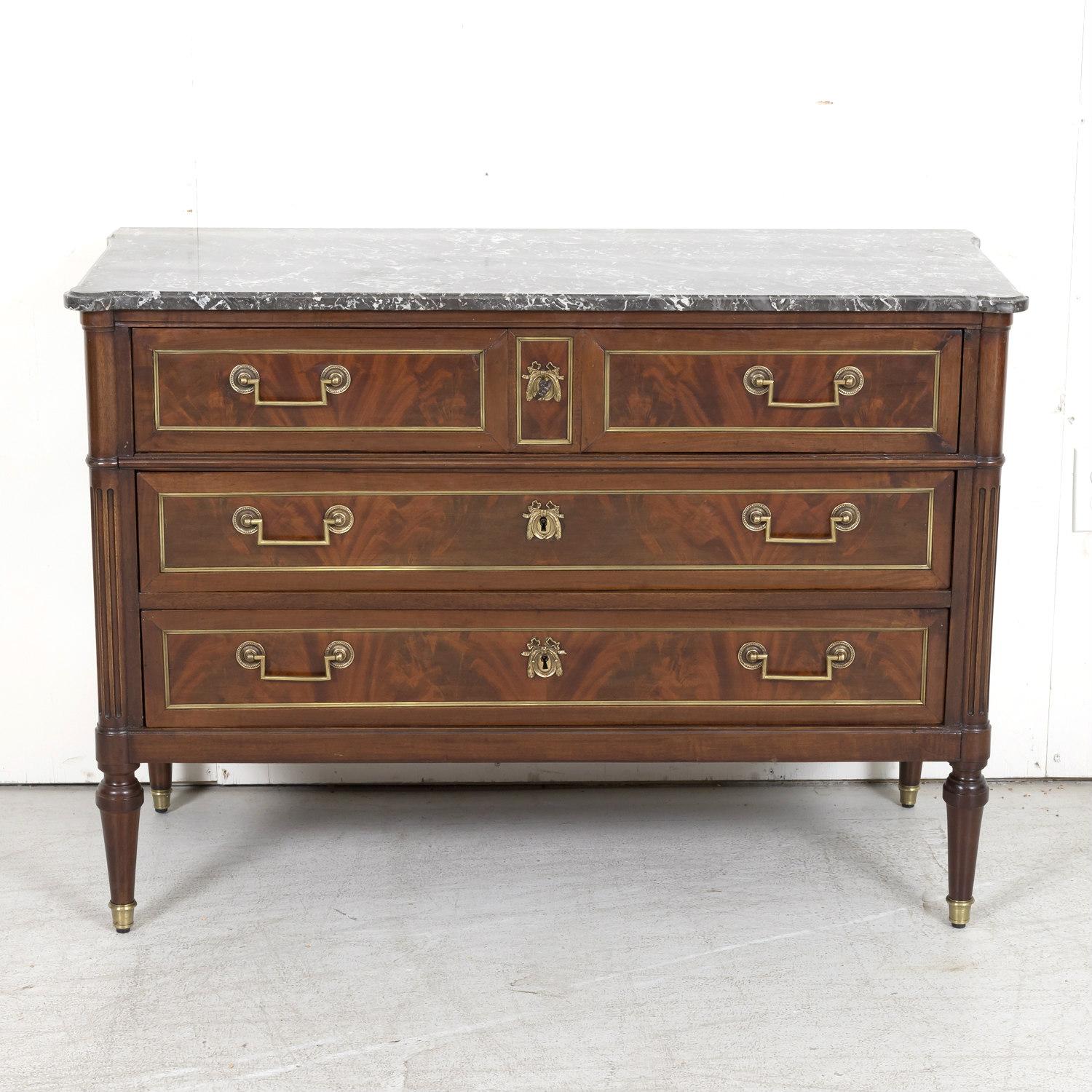 A fine 18th century French Louis XVI period commode de port handcrafted of Cuban mahogany by skilled artisans from the Bordeaux region of France, circa 1770s, having a moulded cookie cutter top of Saint Anne des Pyrenees gray marble above three