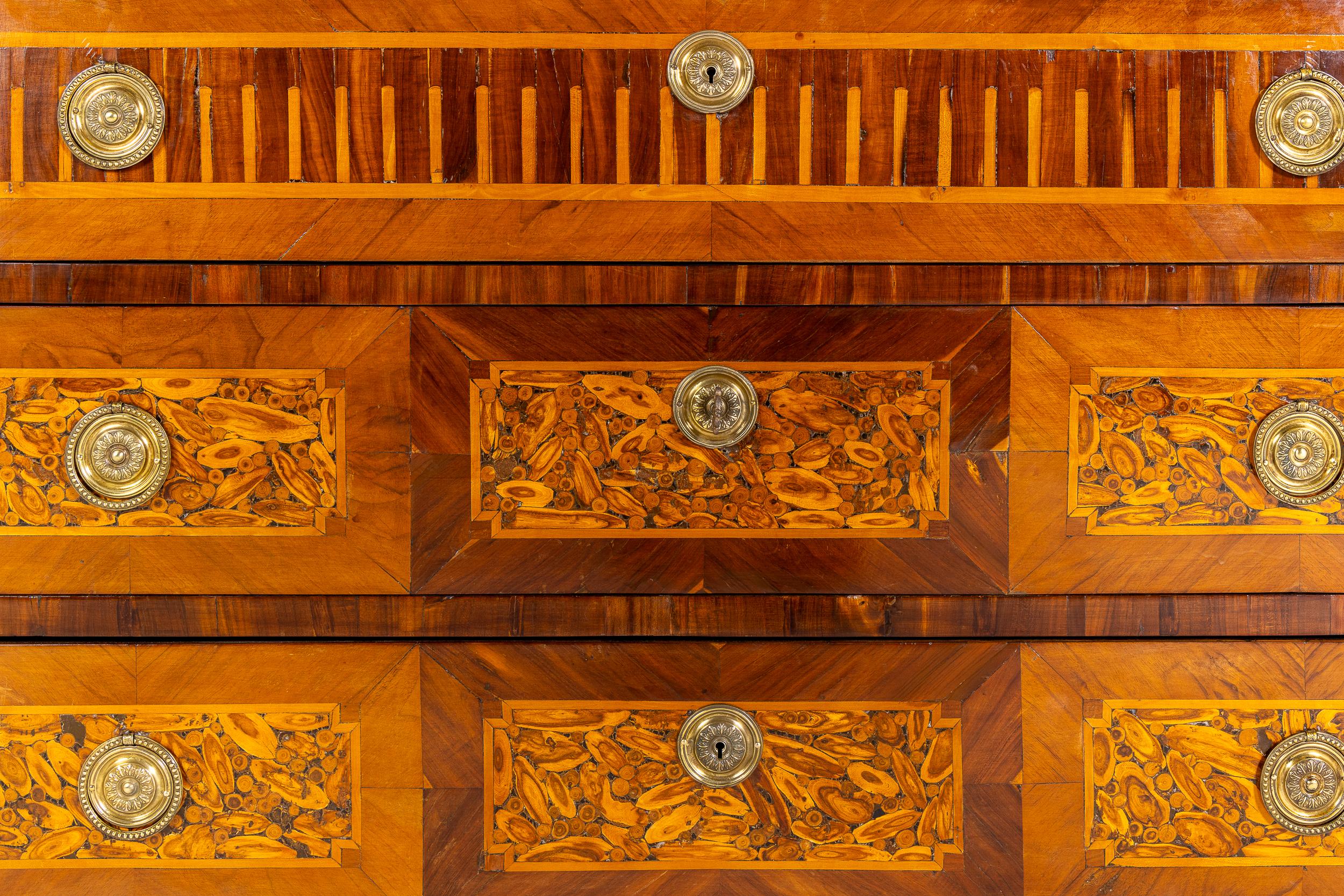 Un'elegante commode francese del periodo Luigi XVI in parquet con un'insolita decorazione impiallacciata di ostriche.

Questa bella commode ha la tipica forma Luigi XVI con angoli smussati, che si riflettono nella forma del piano originale in marmo