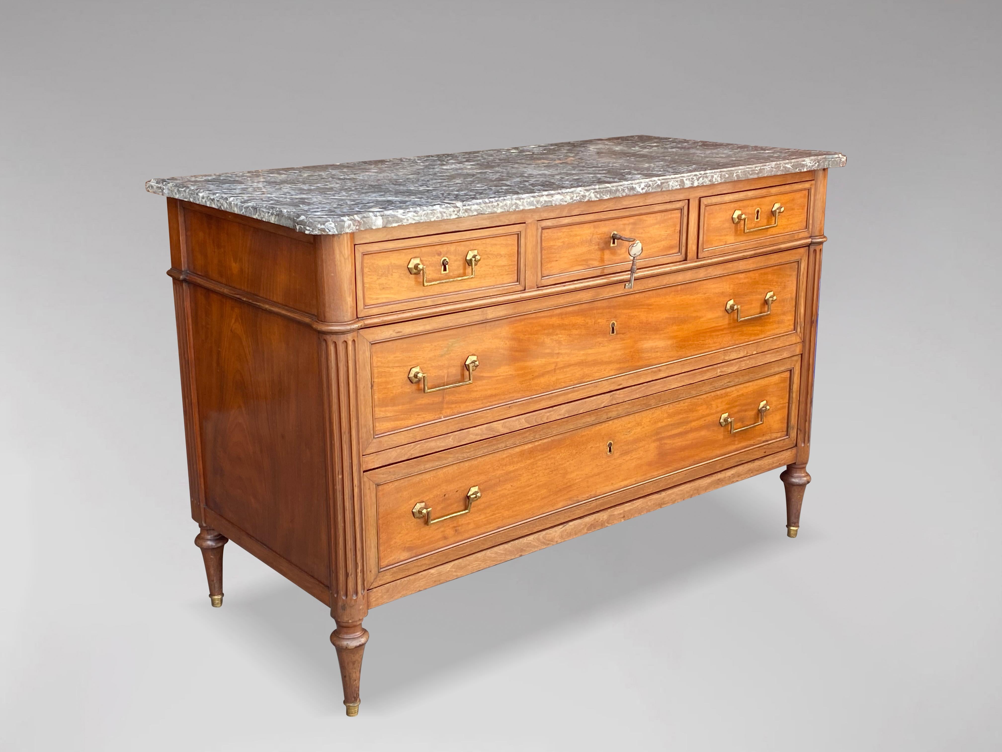 An 18th century French Louis XVI period walnut and marble commode of five drawers, of simple, Neoclassical elegance. Of excellent, long proportions, and retaining its original, shaped and moulded marble top and a nicely-faded, warm-brown walnut