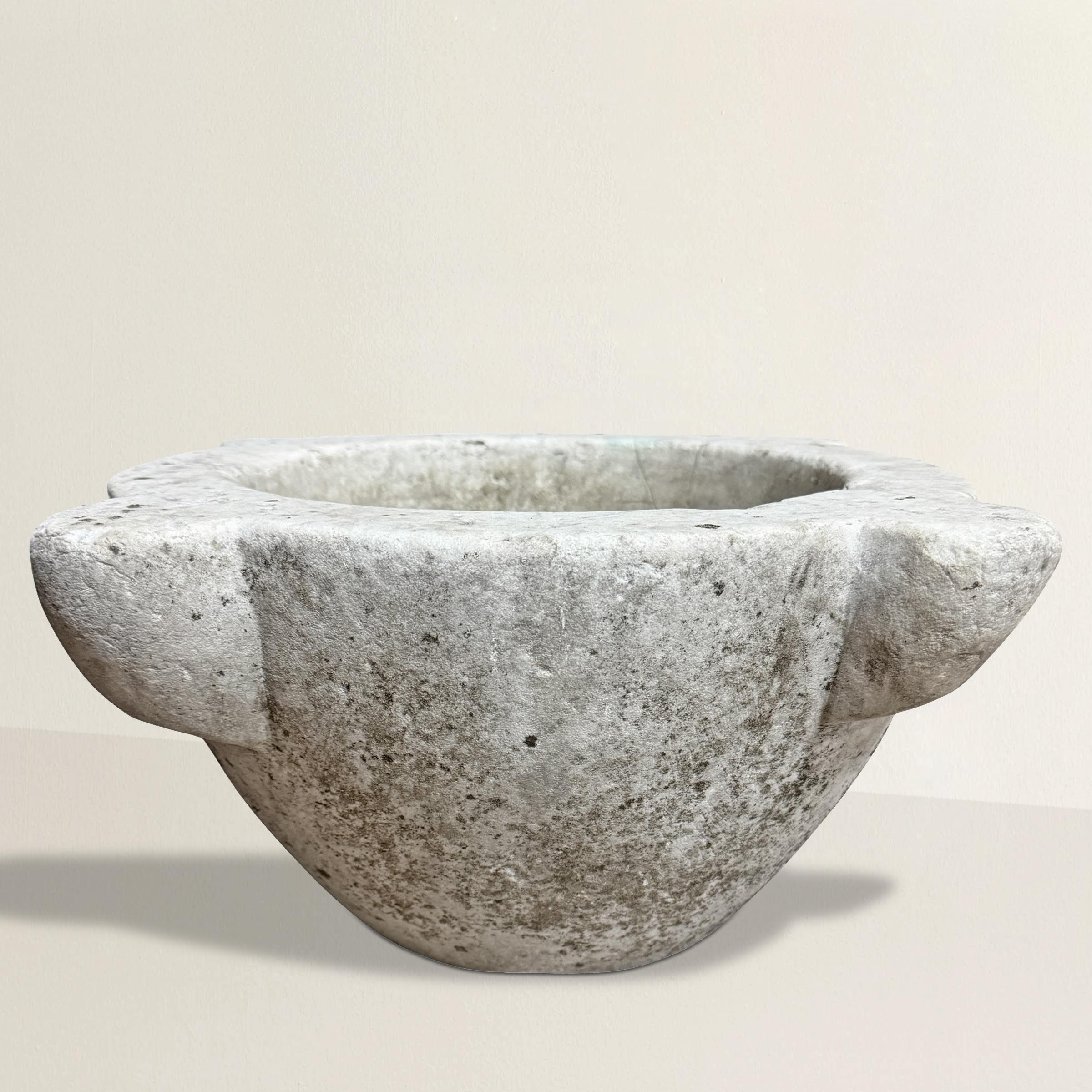 Un mortaio in marmo intagliato francese del XVIII secolo, ricco di storia e ammorbidito da secoli di utilizzo, la cui superficie si è consumata con una patina che solo 250 anni di tradizione culinaria potrebbero impartire. Un tempo strumento