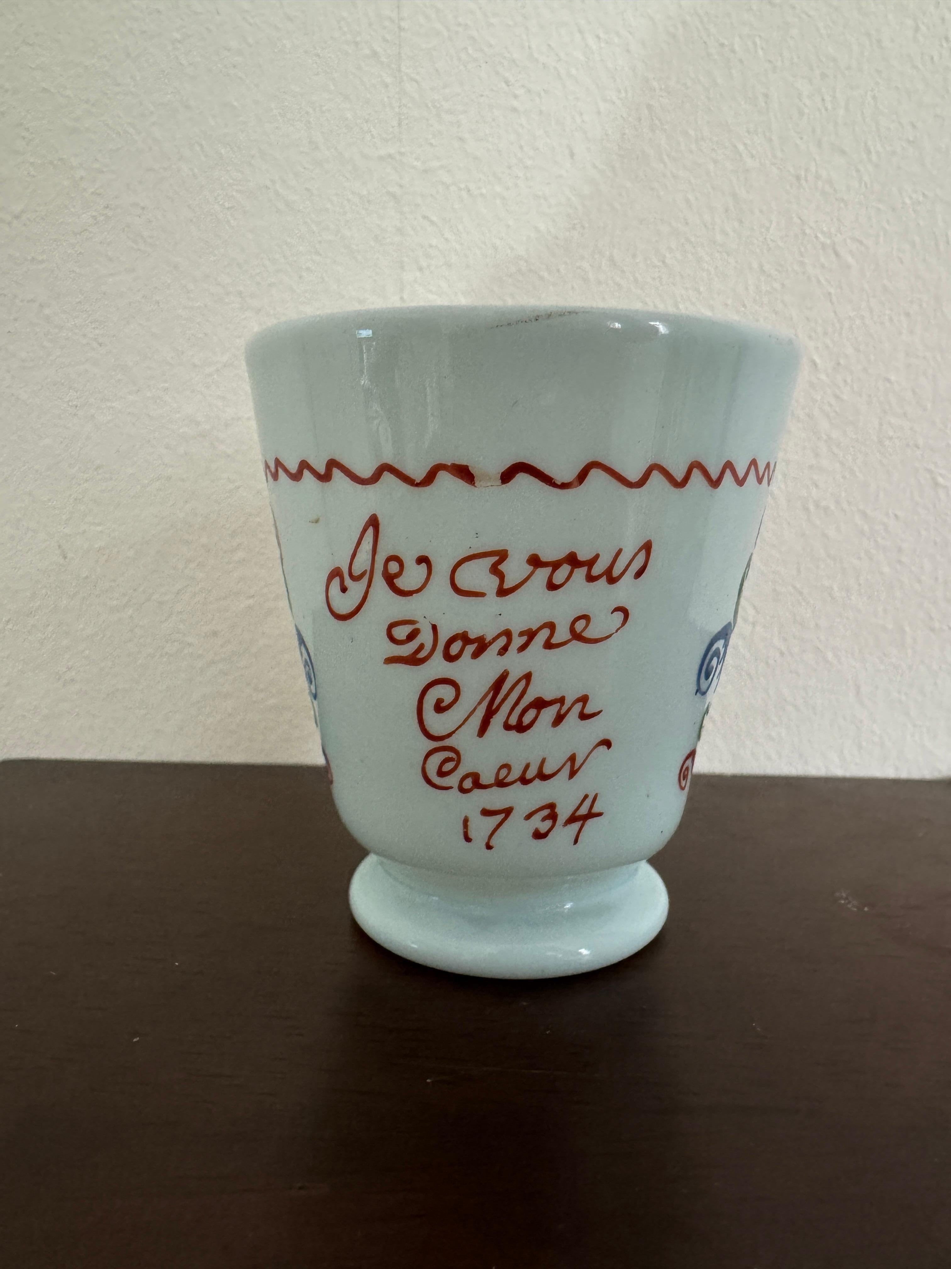 Verre à lait français du XVIIIe siècle, attribué à l'atelier de Bernard Perrot à Orléans. Verre opalin décoré à la main de fleurs et de feuilles rouges, bleues et vertes. Avec une devise française traduite par 