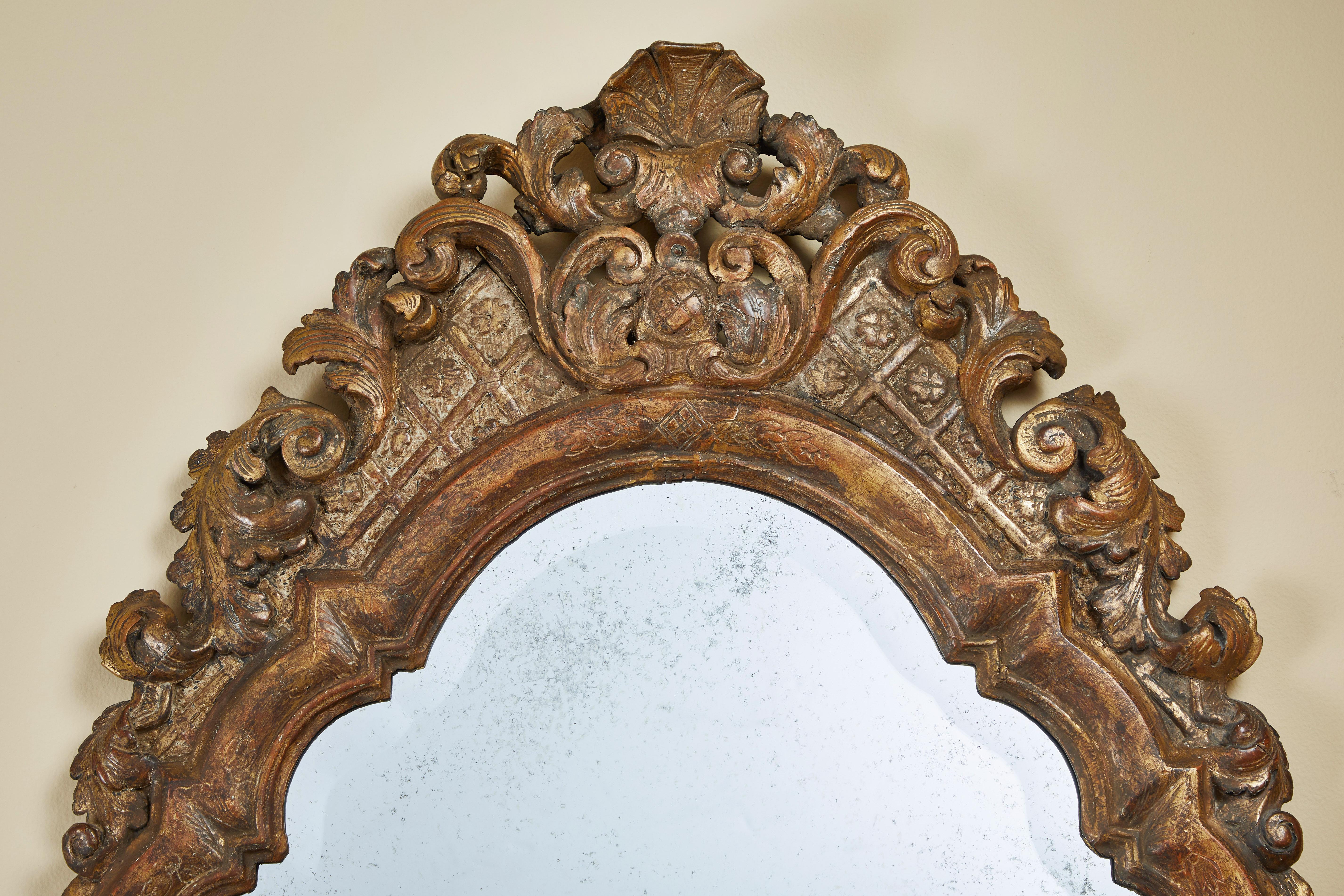 Unique and elegant French mirror with its original patina.
This mirror is hand-carved and gilded.
The glass has a light antique finish and is bevelled.