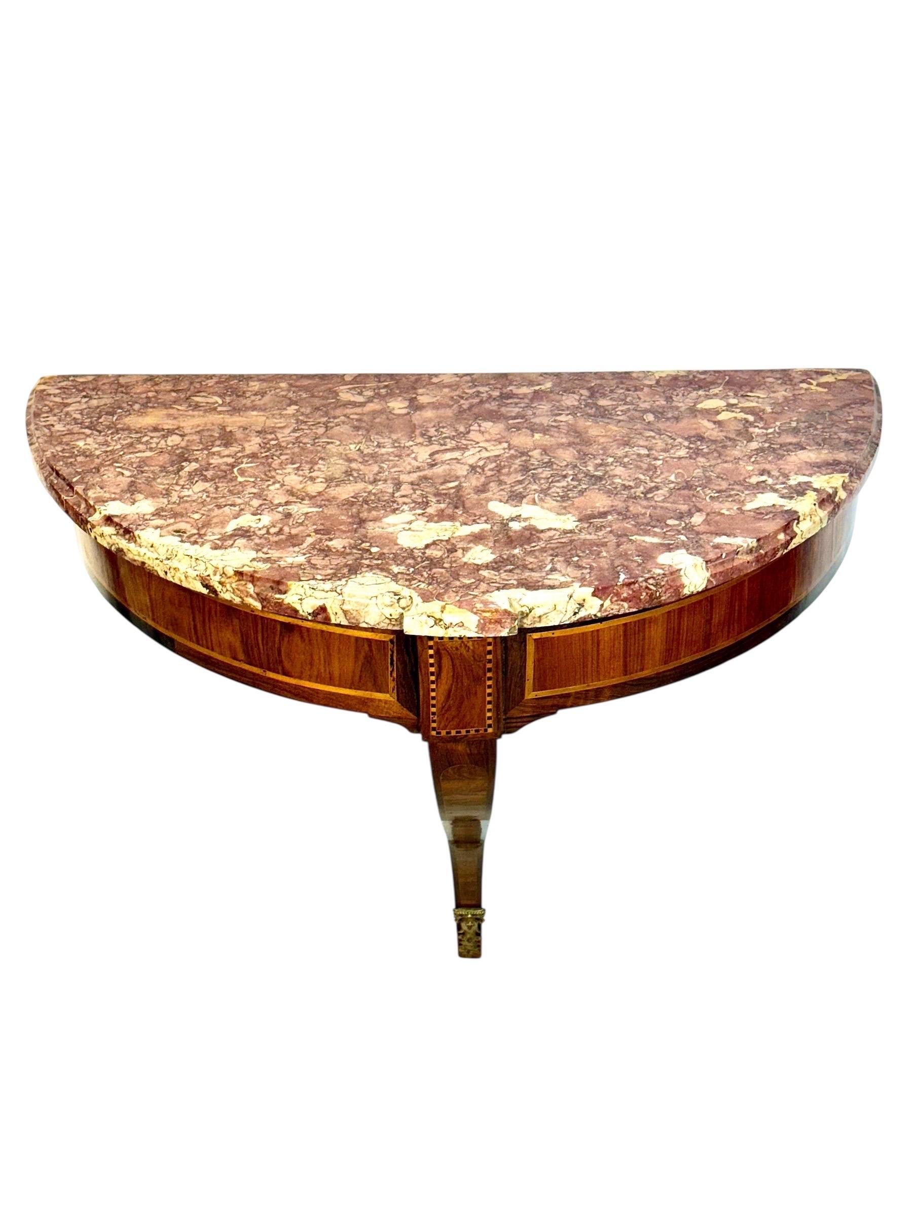 Une élégante console murale néoclassique française datant de la fin du XVIIIe siècle, réalisée avec des proportions raffinées et des matériaux exceptionnels. La structure démilunie est en acajou plaqué, rehaussé de délicats détails incrustés de