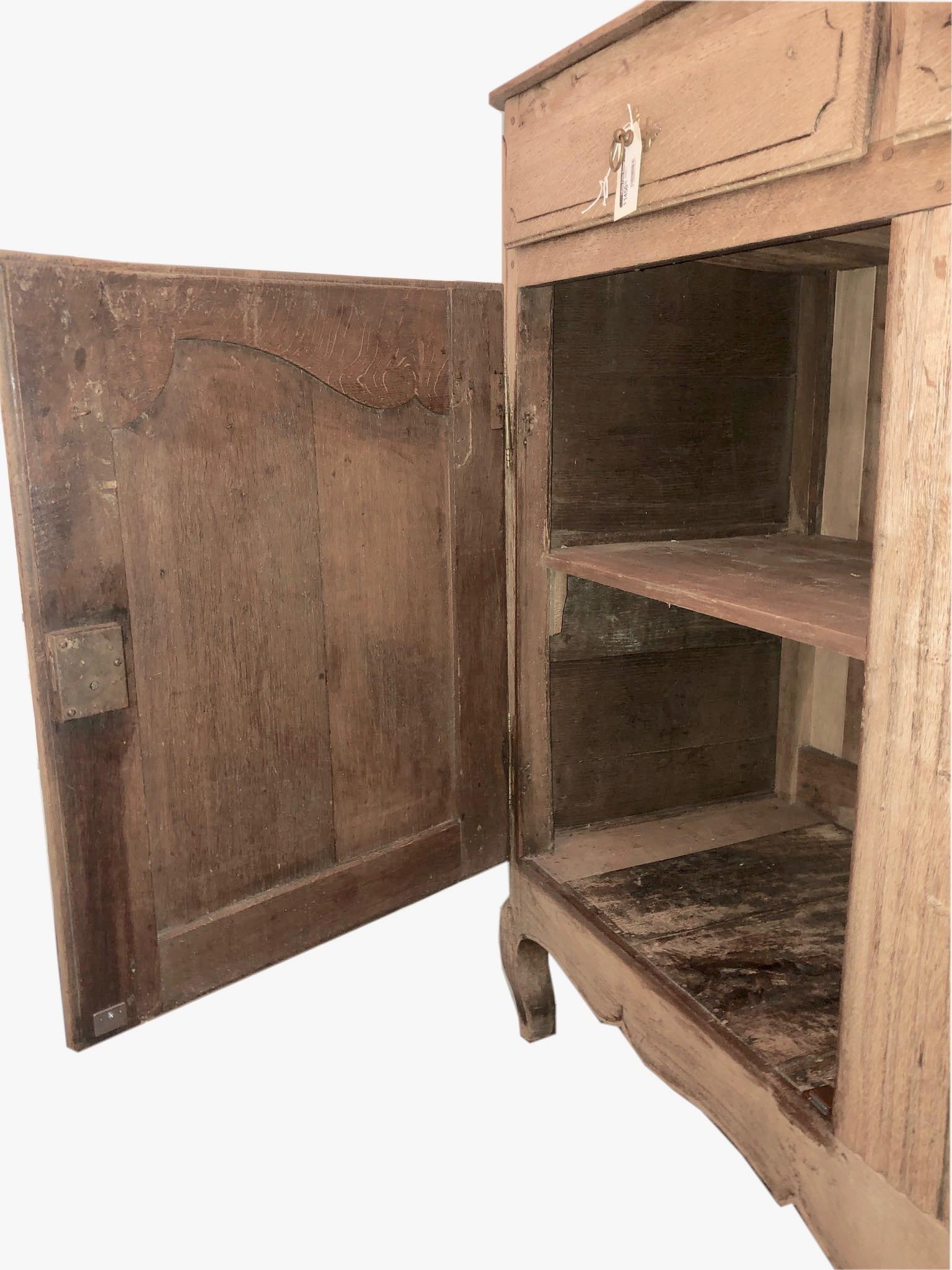 18th century credenza buffet cabinet, of bleached oak, in the Provençal, having a molded rectangular top, over apron of 2 drawers, double cupboard doors open on iron hinges, shaped apron raised on cabriole legs. All hardware is original.