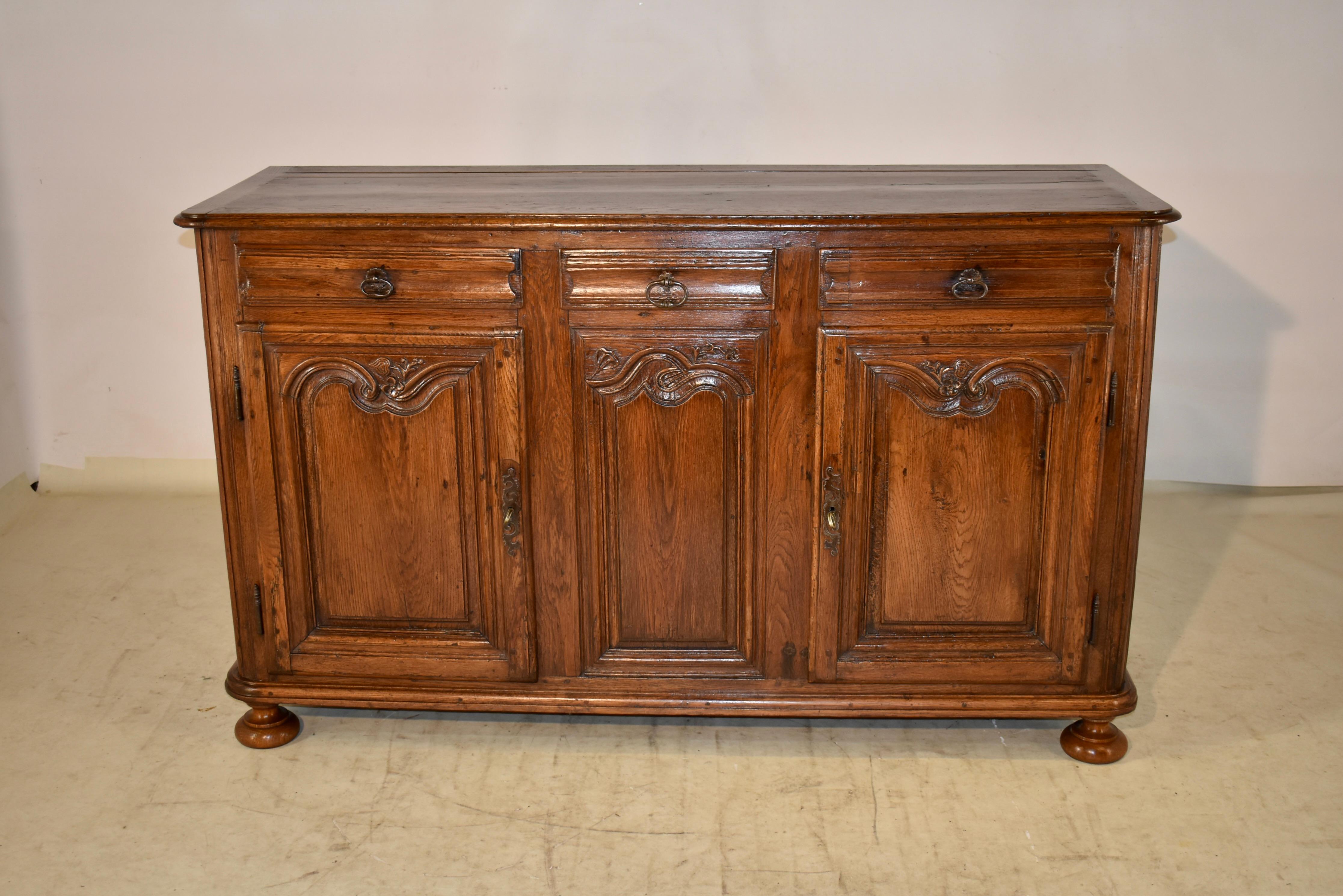 18th century Oak enfilade from France. The top is banded and has a beveled edge and plate groove toward the back of the top. The top follows down to fabulous two paneled sides and three drawers with hand carved drawer fronts in the front of the