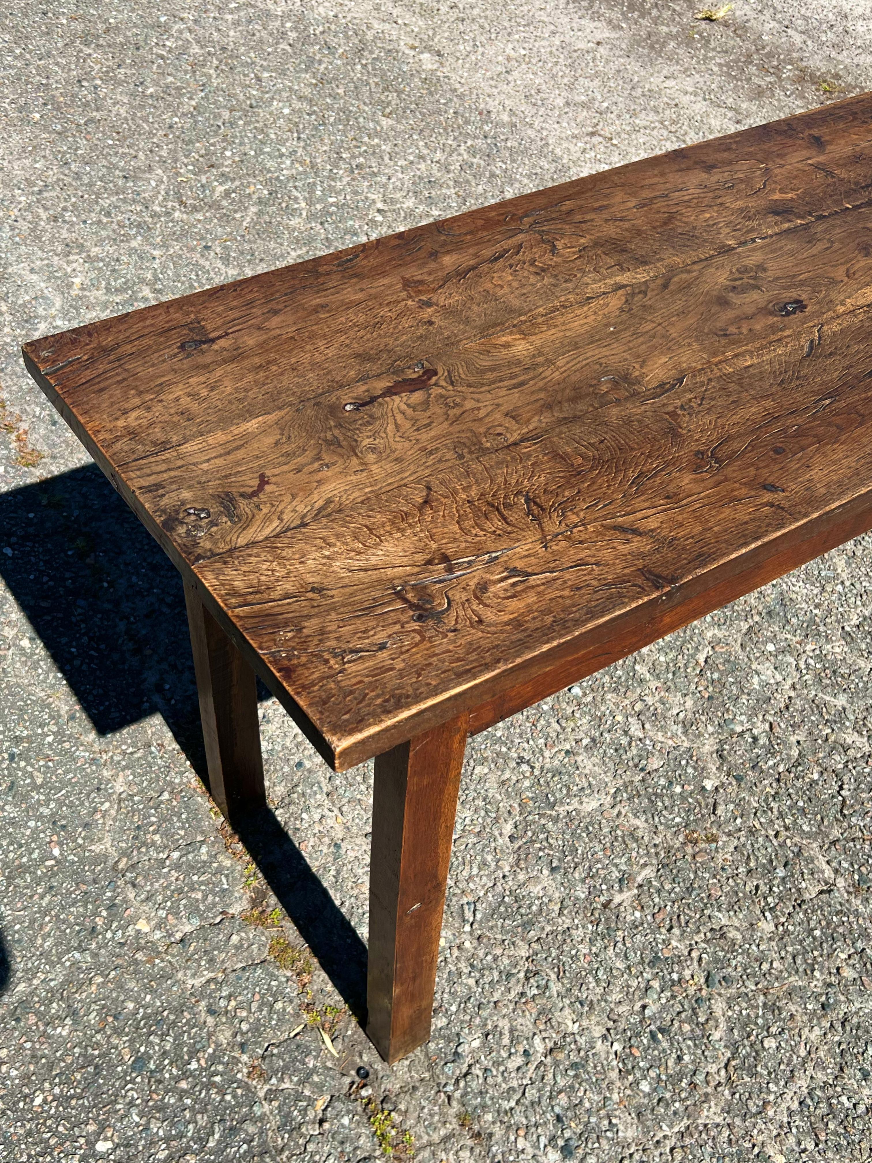 French Oak Farmhouse Table, ideal as a console or writing table.  The top consists of three oak planks and the bottom is a French walnut.  The legs and base have mortise and tenon joints. The table is very sturdy.  The top has developed a warm, nut
