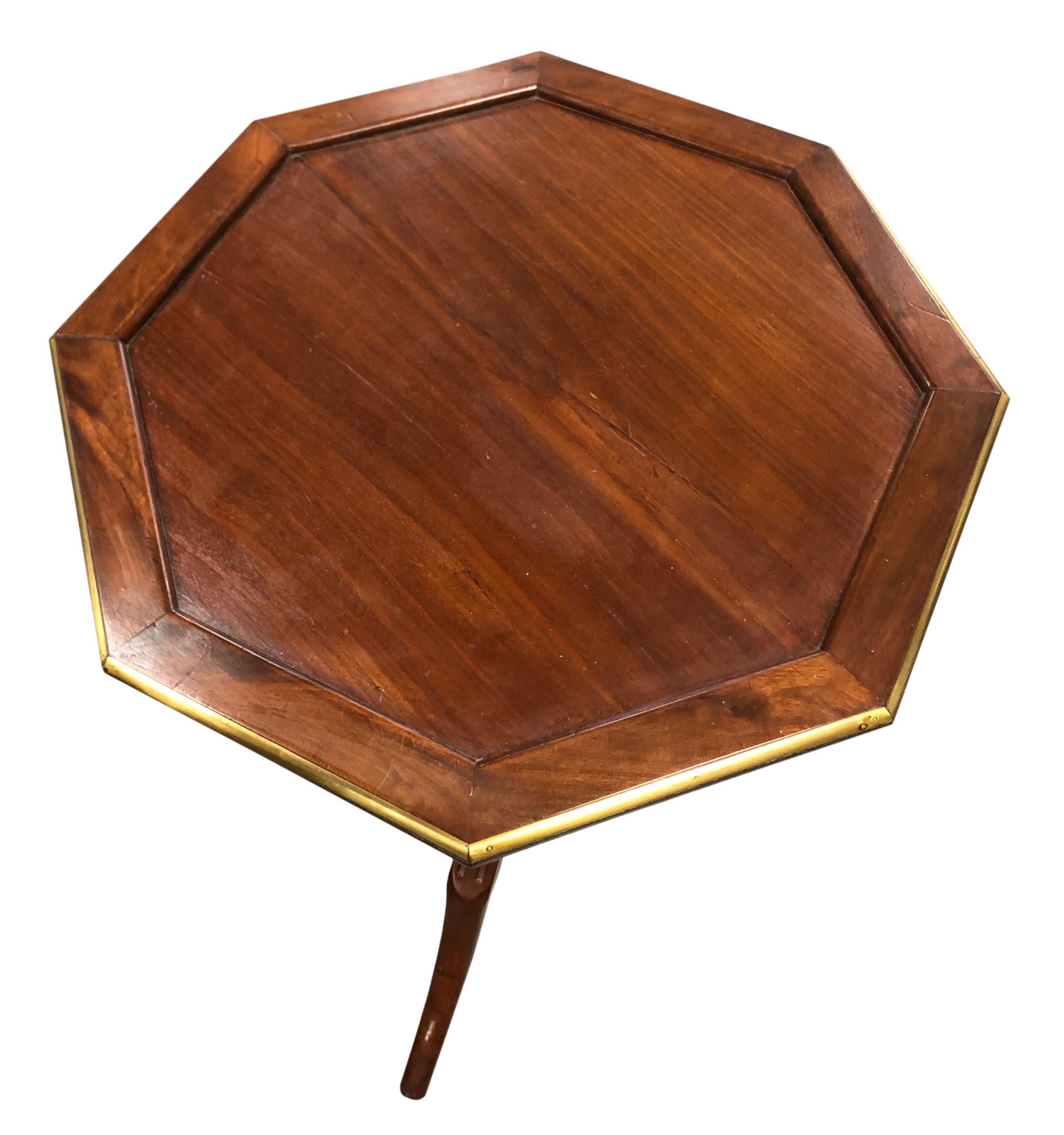 An 18th century octagon shape side table from France. Wood with a beautiful brass edge and is on wheels. It’s not in its original state it used to be a tilt top now it is stationary.