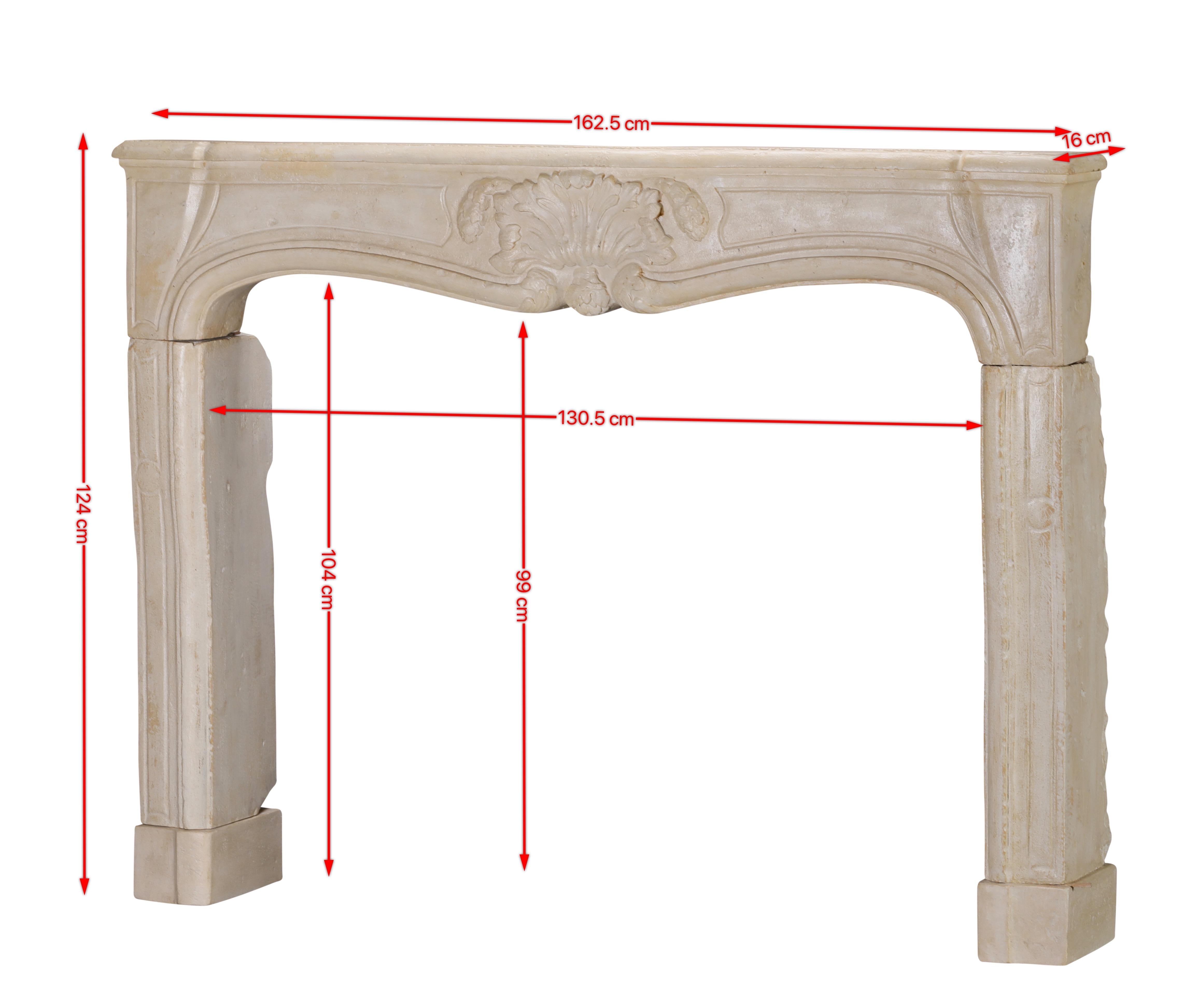 Questo autentico camino in pietra calcarea francese del XVIII secolo sfoggia un'eleganza country-chic senza tempo. Realizzato in pietra calcarea bianca dura, presenta stipiti graziosamente curvi e un motivo a conchiglia/cartouche delicatamente