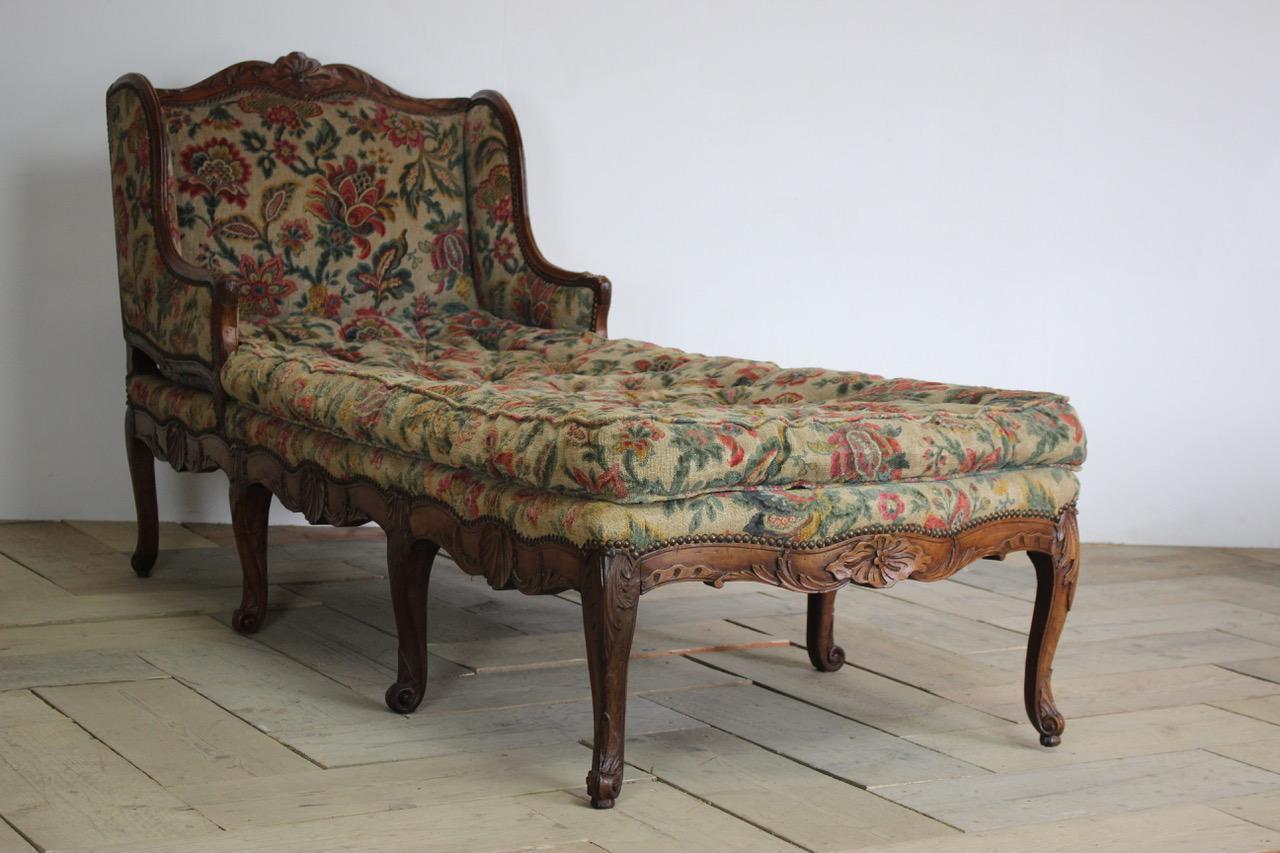 A very smart, 18th century French chaise longue of great proportions in elm and fruitwood, with cabriole legs and scallop carvings.