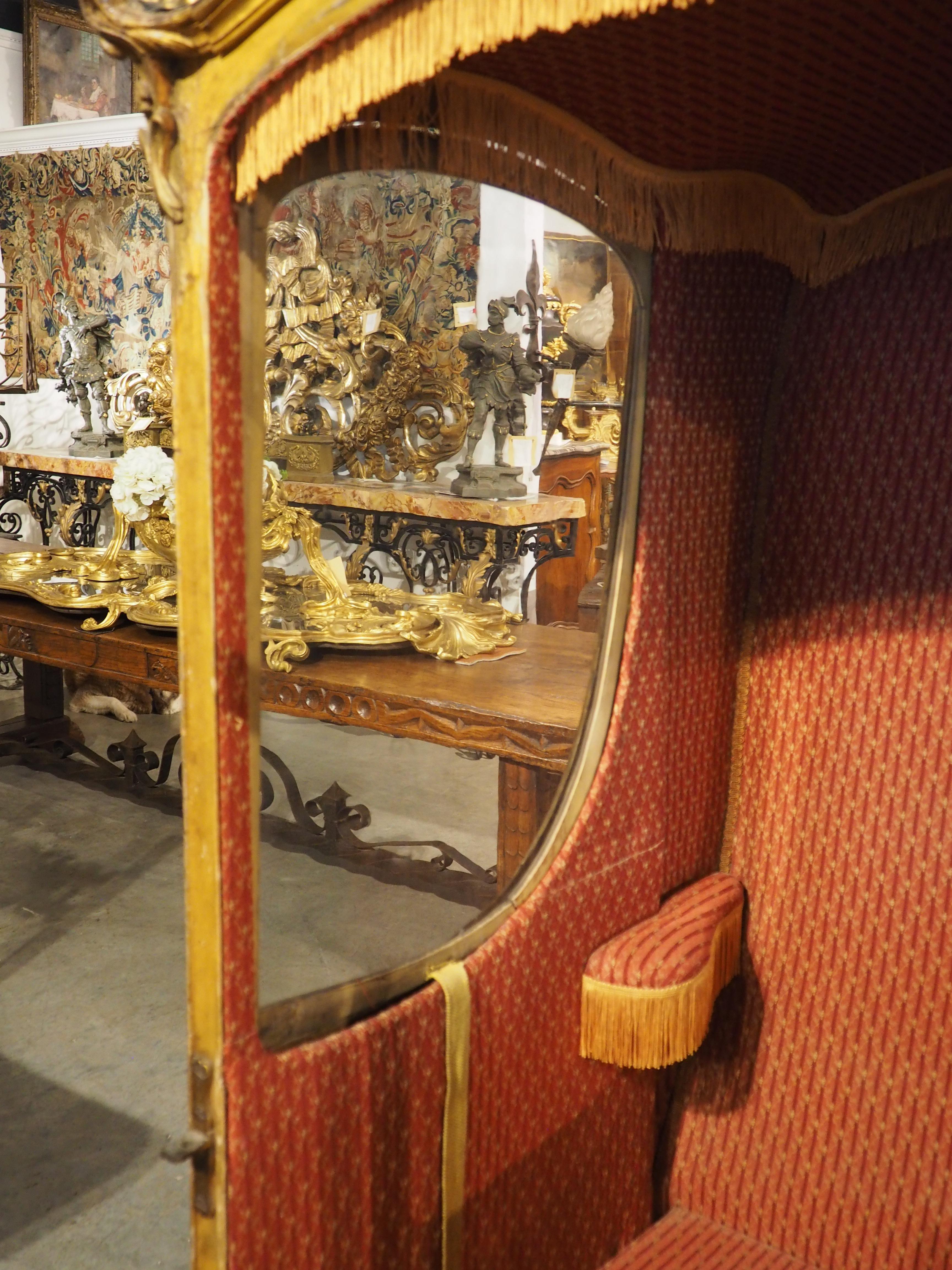 Known in France as chaise à porteurs, this painted and gilded sedan chair dates to the 1700s. The front door and the sides have been painted green, with a flowering “K” in gold, entangled by blue, white, and red blooms. In place of the monogram, the