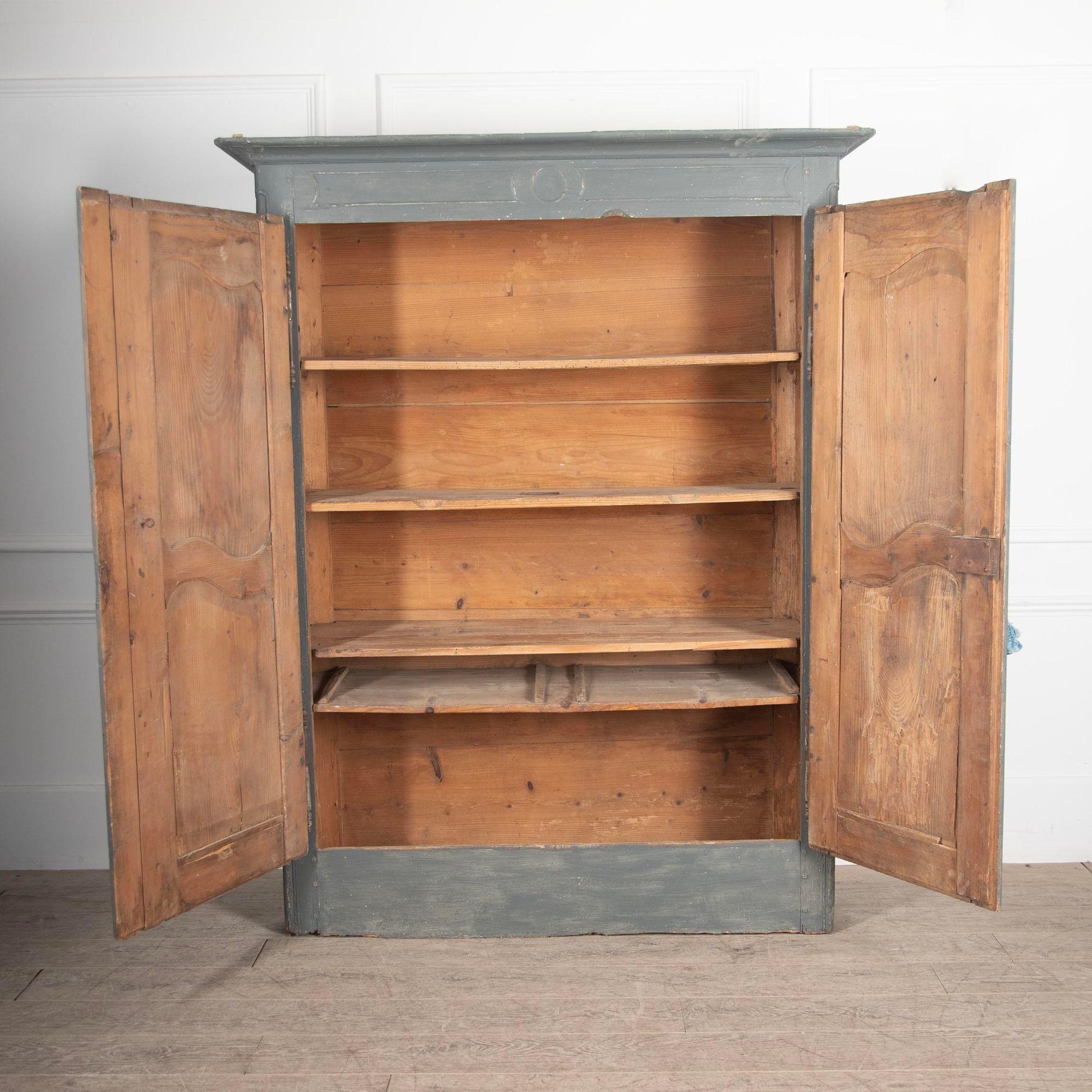 18th Century French Pine Louis XV armoire.This rustic but authentic piece features its original key, hinges and escutcheons. Details such as the paneled doors and touches of carved details are all typical of the Louis XV period.The exterior has had