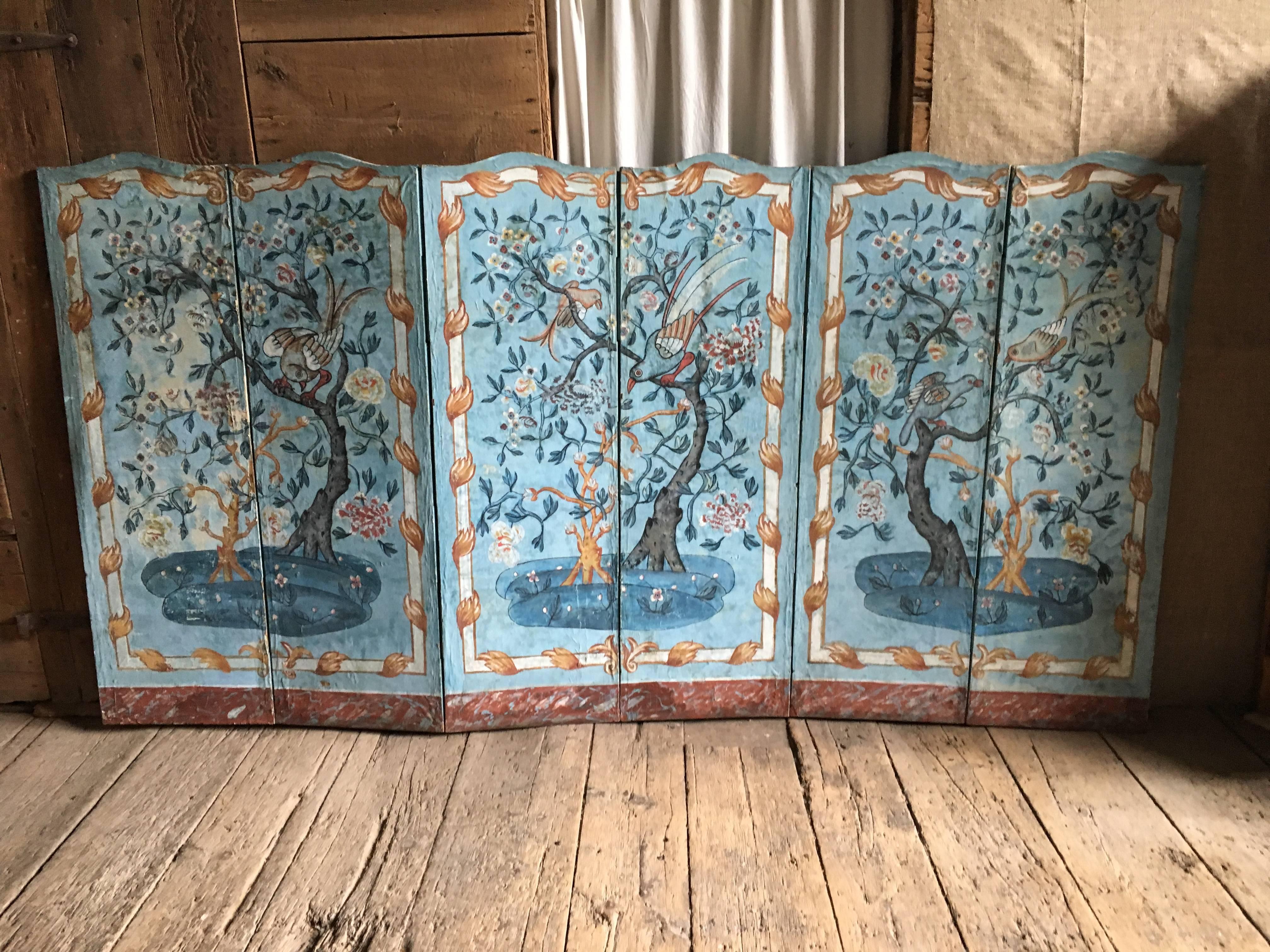 A charming Provincial French hand-painted wallpaper six-panel screen (paravent). The screen is decorated with trees, vines, flowers and exotic birds and was inspired by the fine chinoiserie wallpapers of the period found in the finest homes of the