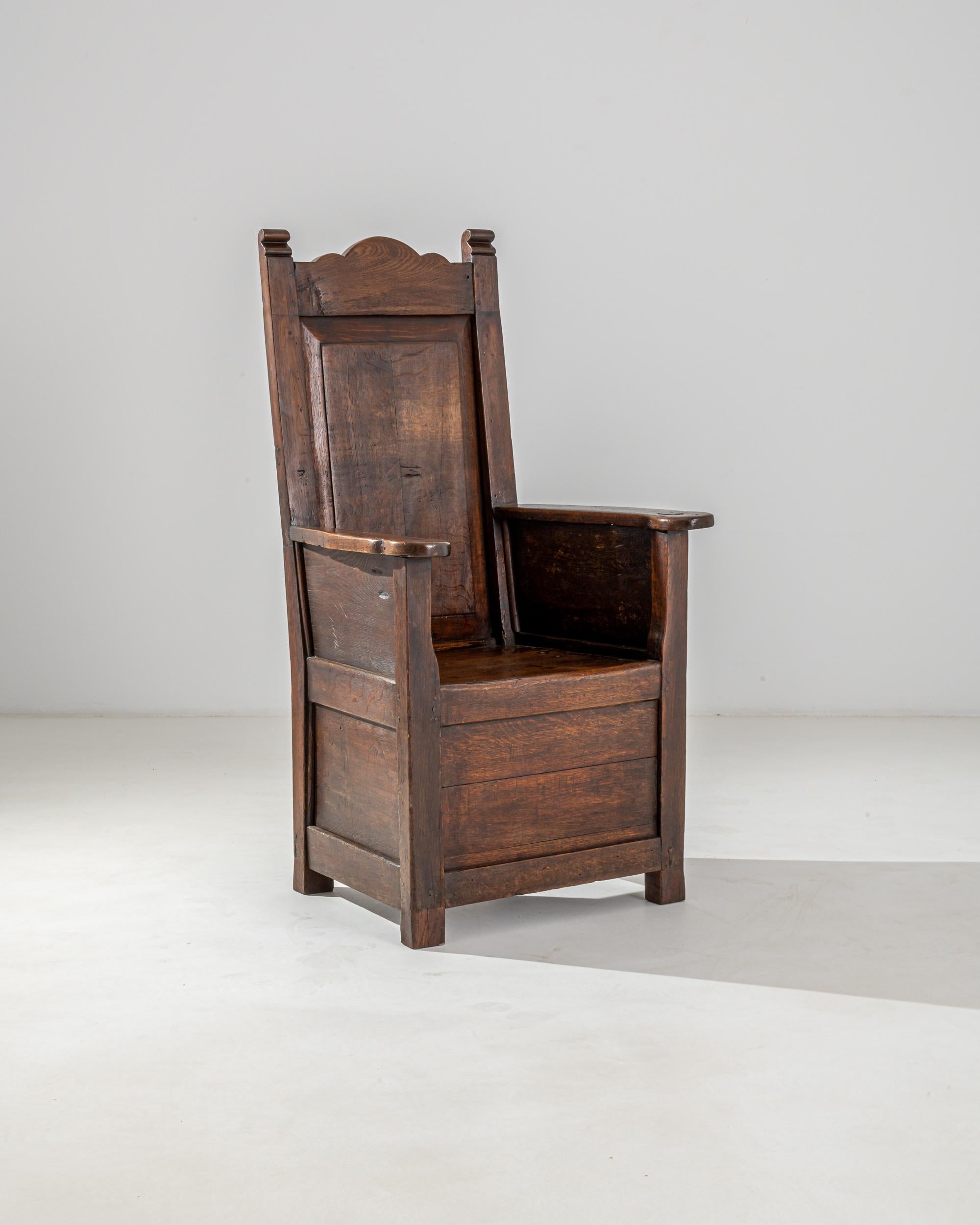 Die thronartige Silhouette und die reiche Patina verleihen diesem antiken Stuhl eine erhabene Würde. Im 18. Jahrhundert in Frankreich erbaut - vor der Einführung des elektrischen Lichts - hätten die tiefe Politur und der warme rubinrote Farbton des