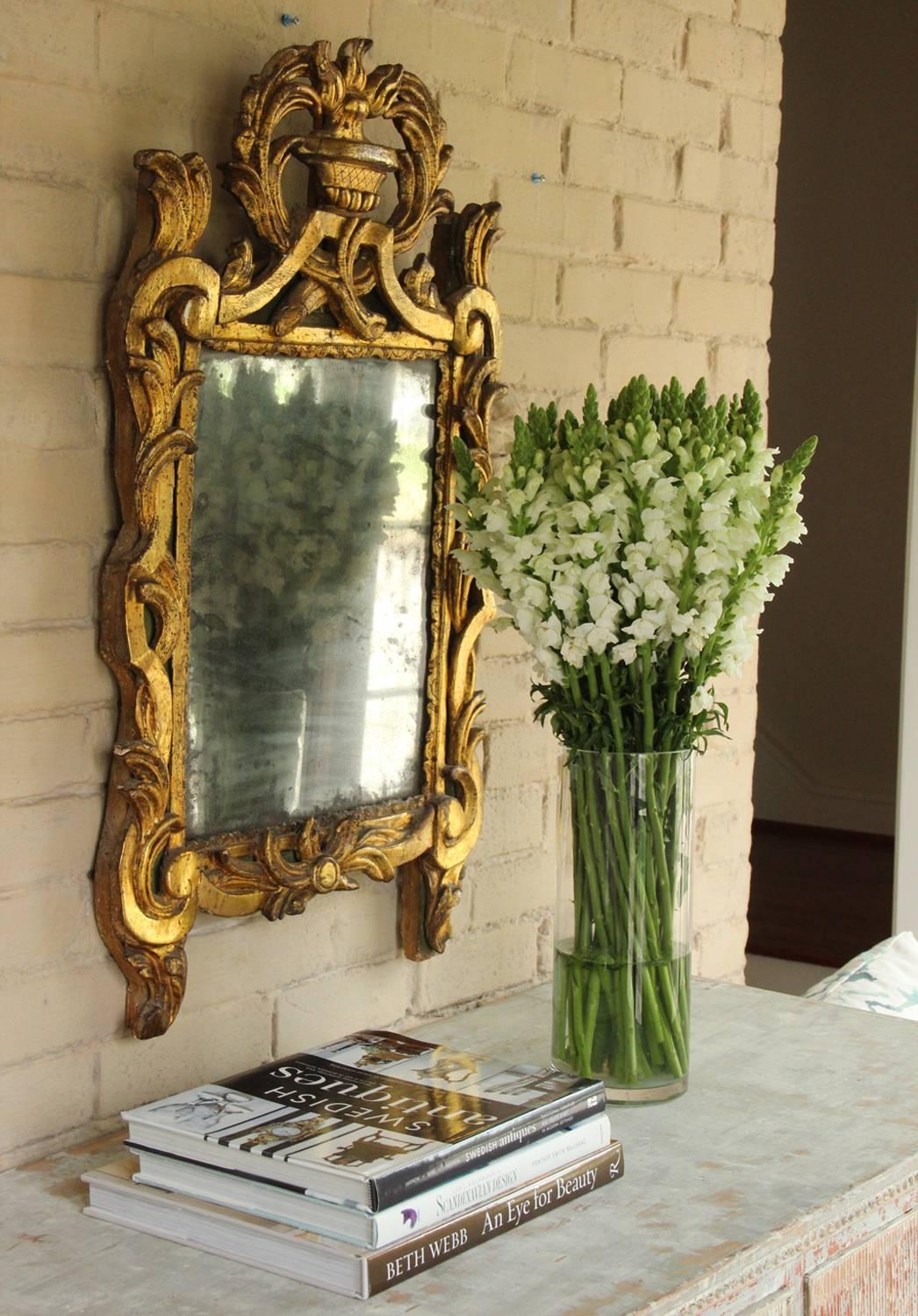 A Louis XVI ‘Louis Seize’ period carved painted and parcel giltwood wall mirror with urn pediment from the 18th century. Original mercury mirror plate.