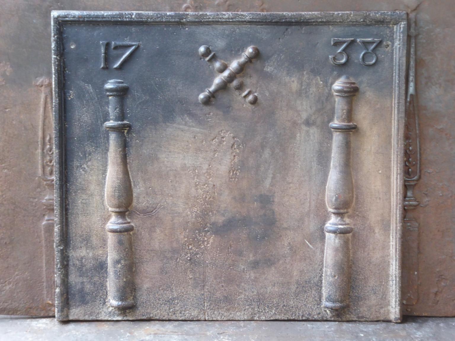 18th century French Louis XV fireback with two pillars, a cross, and the date of production 1738. The pillars refer to the club of Hercules and symbolize strength and the unknown. The cross refers to Saint Andrew's Cross. Saint Andrew is said to