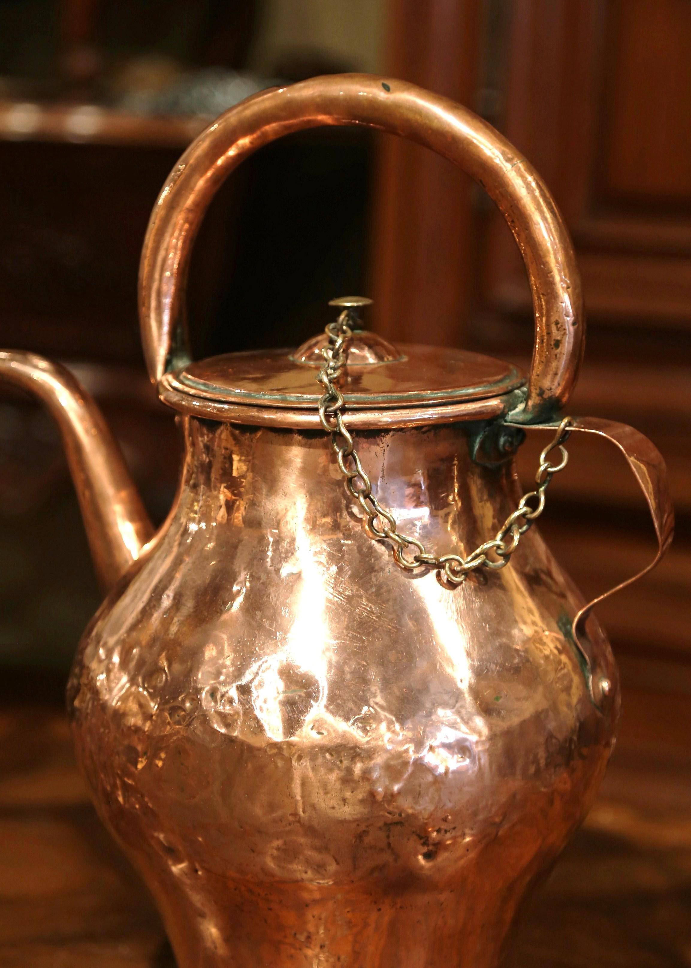 Decorate a kitchen cabinet with this elegant antique country pitcher. Crafted in Normandy, France circa 1780, and made of copper, the large hot water pitcher features a double handle and a lid tied with a chain. The rustic recipient is in excellent