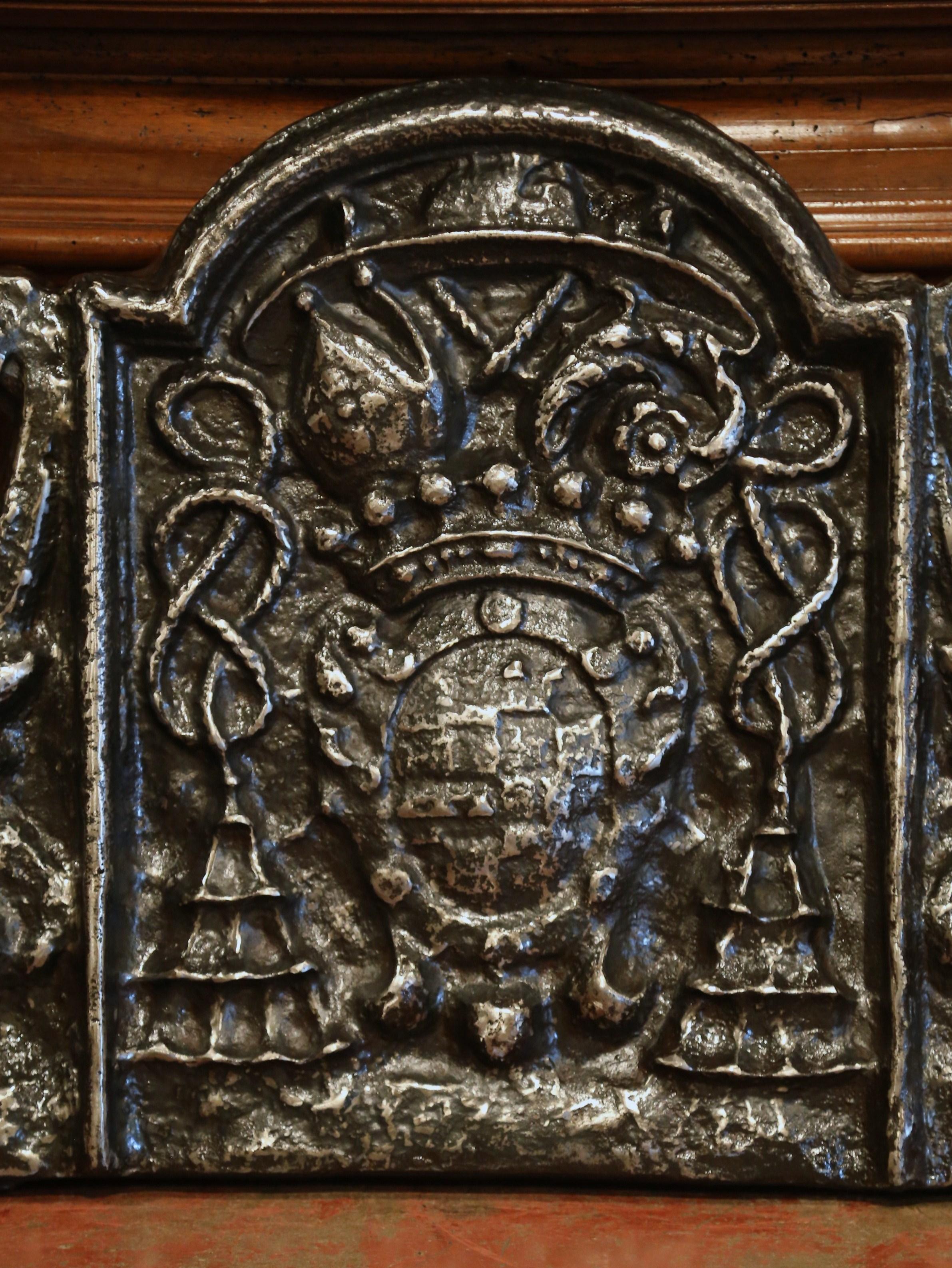 This massive French antique fire back was crafted in Southern France, circa 1750. With an arched top and scrolled sides, the thick fireplace essential features a aristocratic family coat of arms topped with a regal crown. The heavy decorated forged