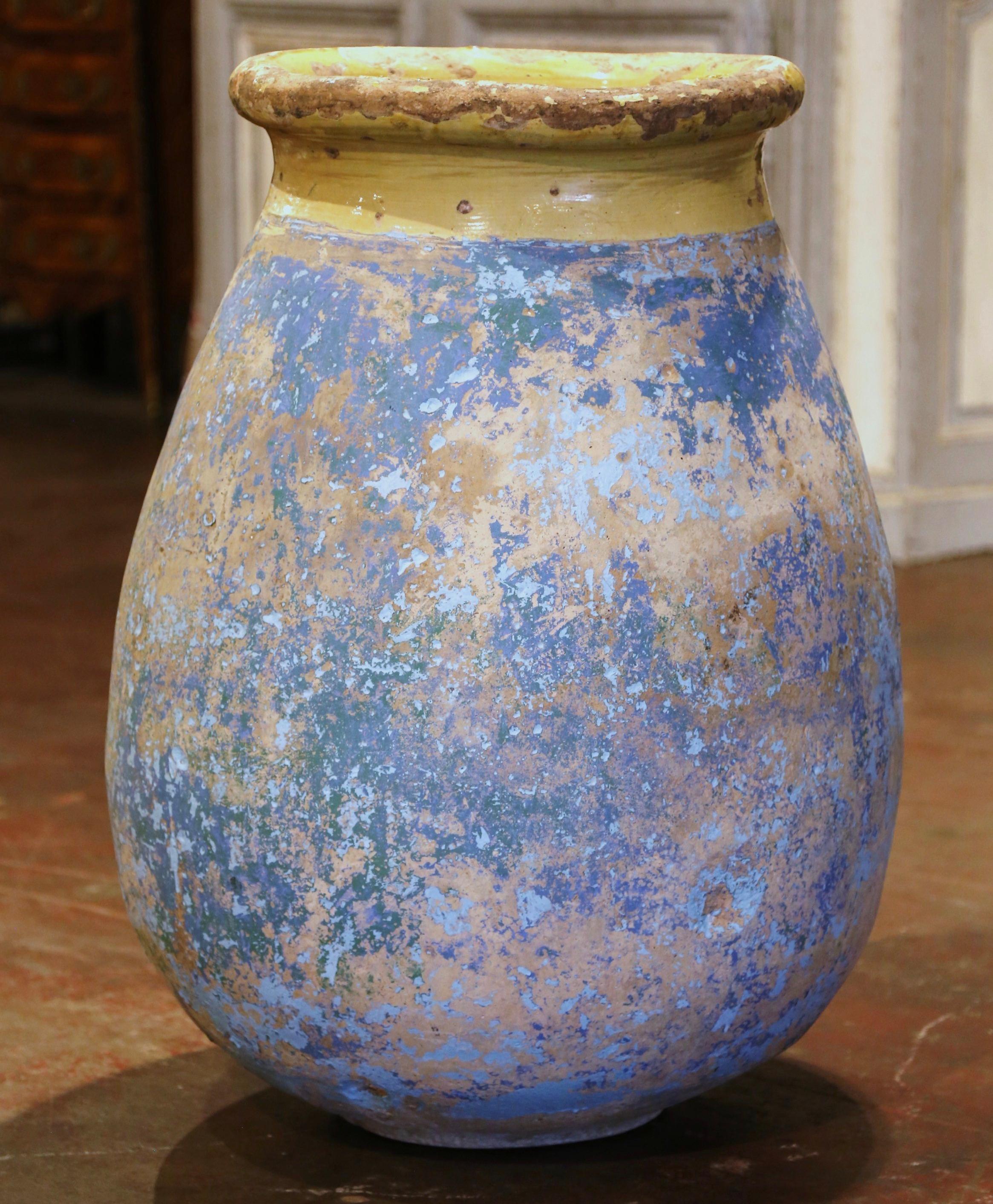 Dieser große, antike Olivenkrug aus Steingut wurde um 1760 in Biot, Provence, Südfrankreich, hergestellt. Die farbneutrale Terrakotta-Vase aus blondem Ton hat eine traditionelle runde, bauchige Form. Die rustikale, von der Zeit gezeichnete Kanne