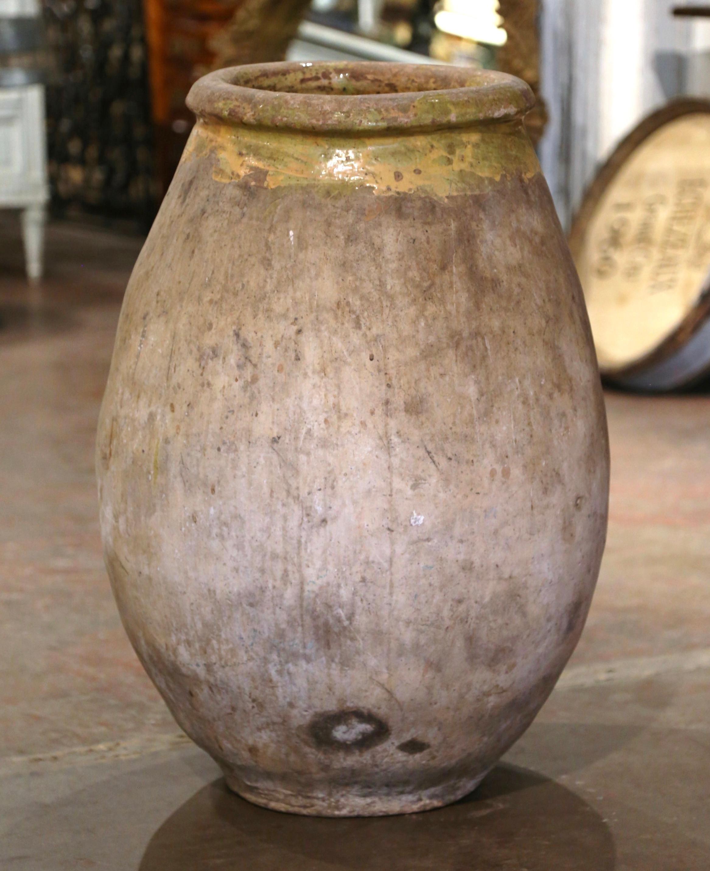 Cette grande jarre à huile d'olive en faïence a été créée à Biot, en Provence, dans le sud de la France, vers 1760. Fabriqué en argile blonde et de couleur neutre, le vase en terre cuite a une forme ronde et bulbeuse traditionnelle. Ce pot rustique