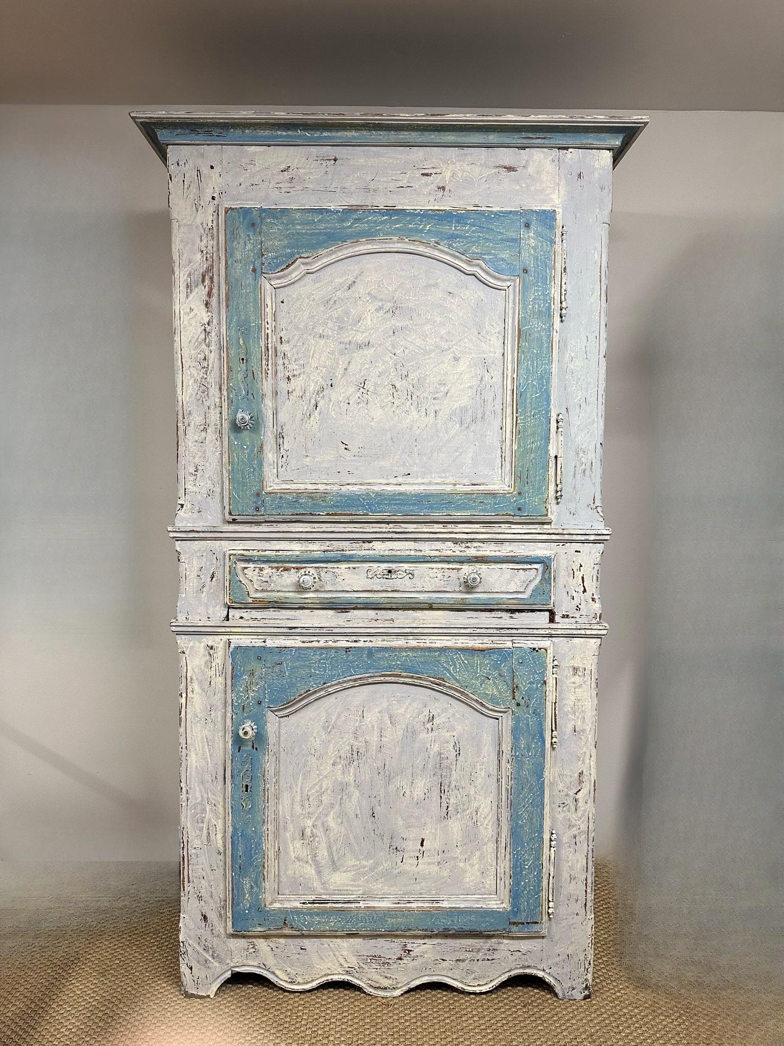 18th Century French Provincial “Bonnetiere.” Great Proportions.  An Arched paneled door above and below a single drawer. Made in two parts with a scalloped apron. Made of Pine with an old painted finish. Normandy Circa 1780.