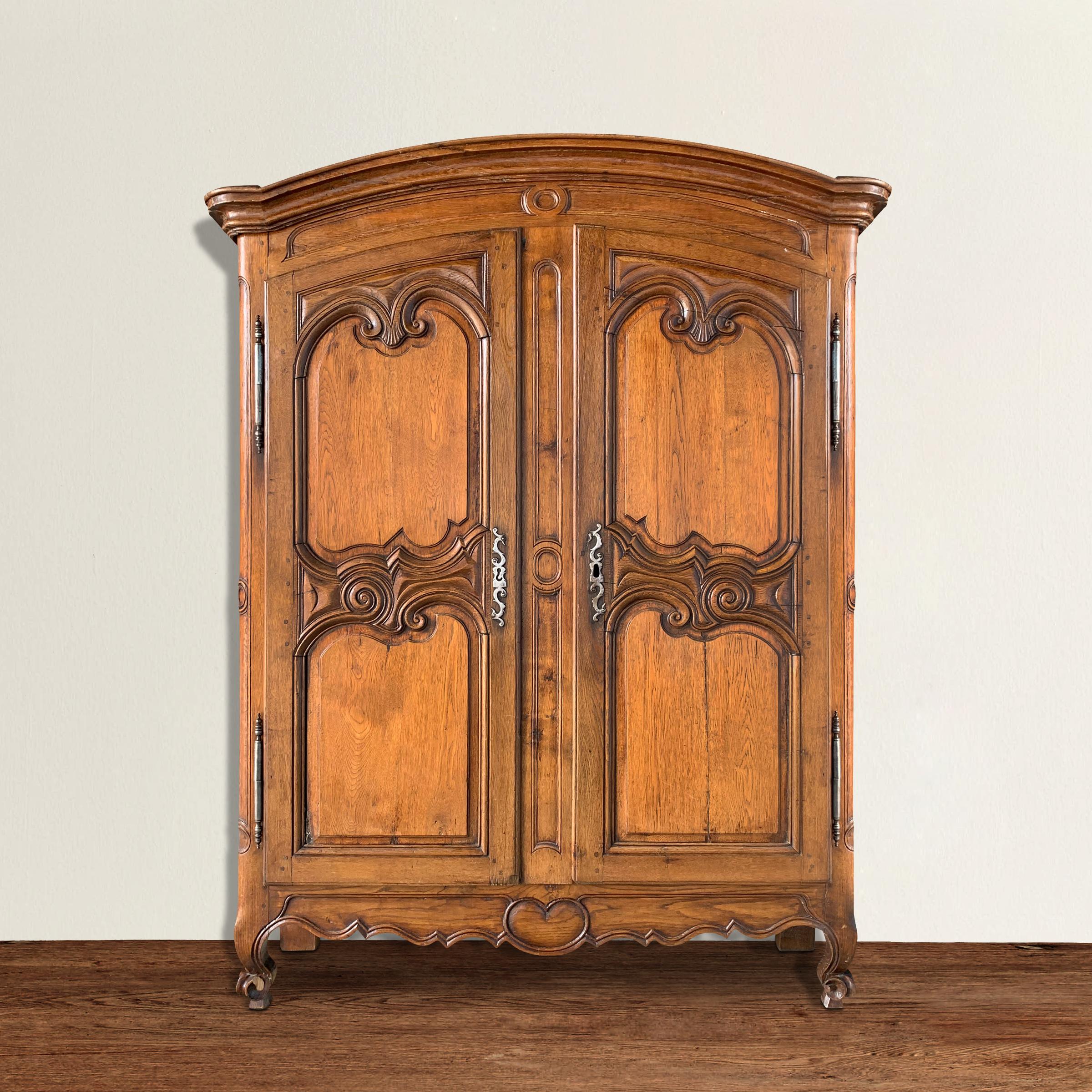 A fantastic 18th century French provincial two-door oak cabinet with wonderful sculptural carved raised panels, apron, and legs, and retaining its original rim lock and key. Cabinet is shallows which makes it perfect for use as a television and/or