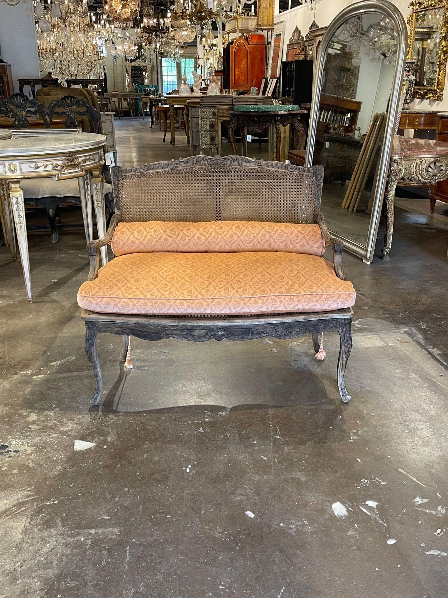 Elegant 18th century French Provincial carved and bleached walnut settee. Upholstered in a gold damask fabric. The piece also have nice carvings a cane back. So pretty!!