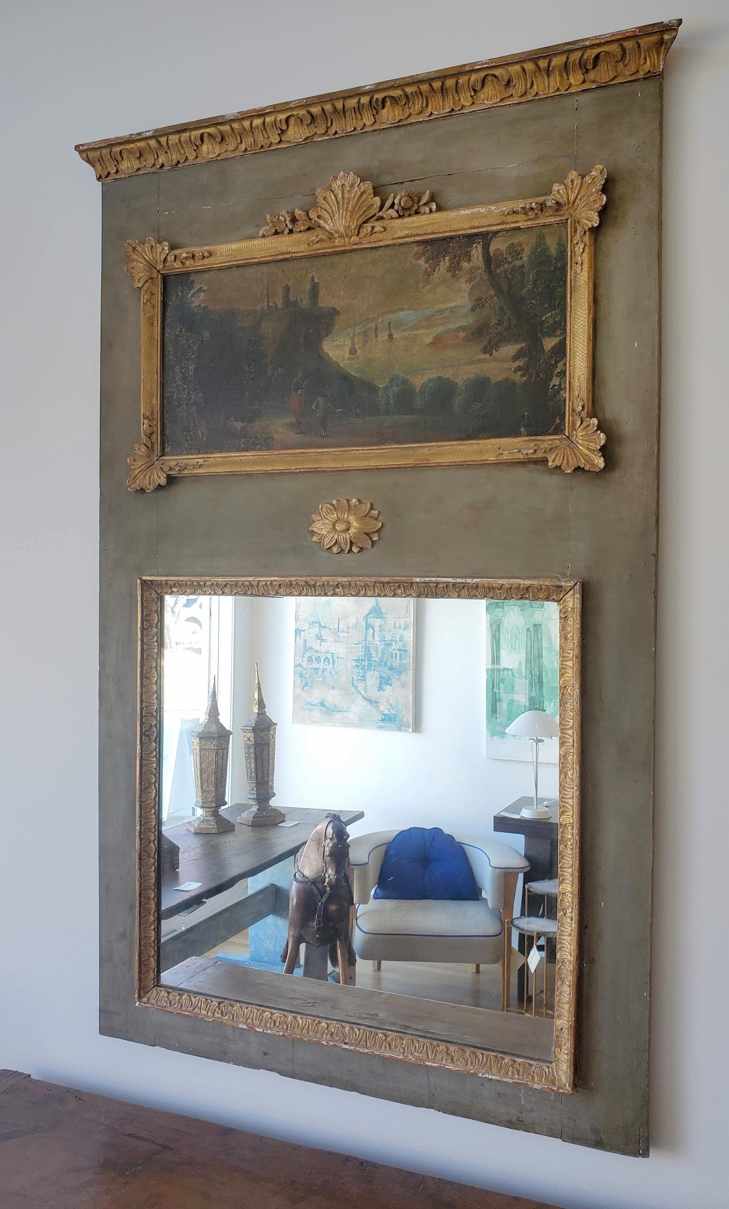 18th Century French Provincial Louis XVI Period Trumeau mirror. Finely carved and molded decoration retaining the original gilding and green painted finish. Central mirror with oil painting above depicting coastal scene with ships and ancient ruins.