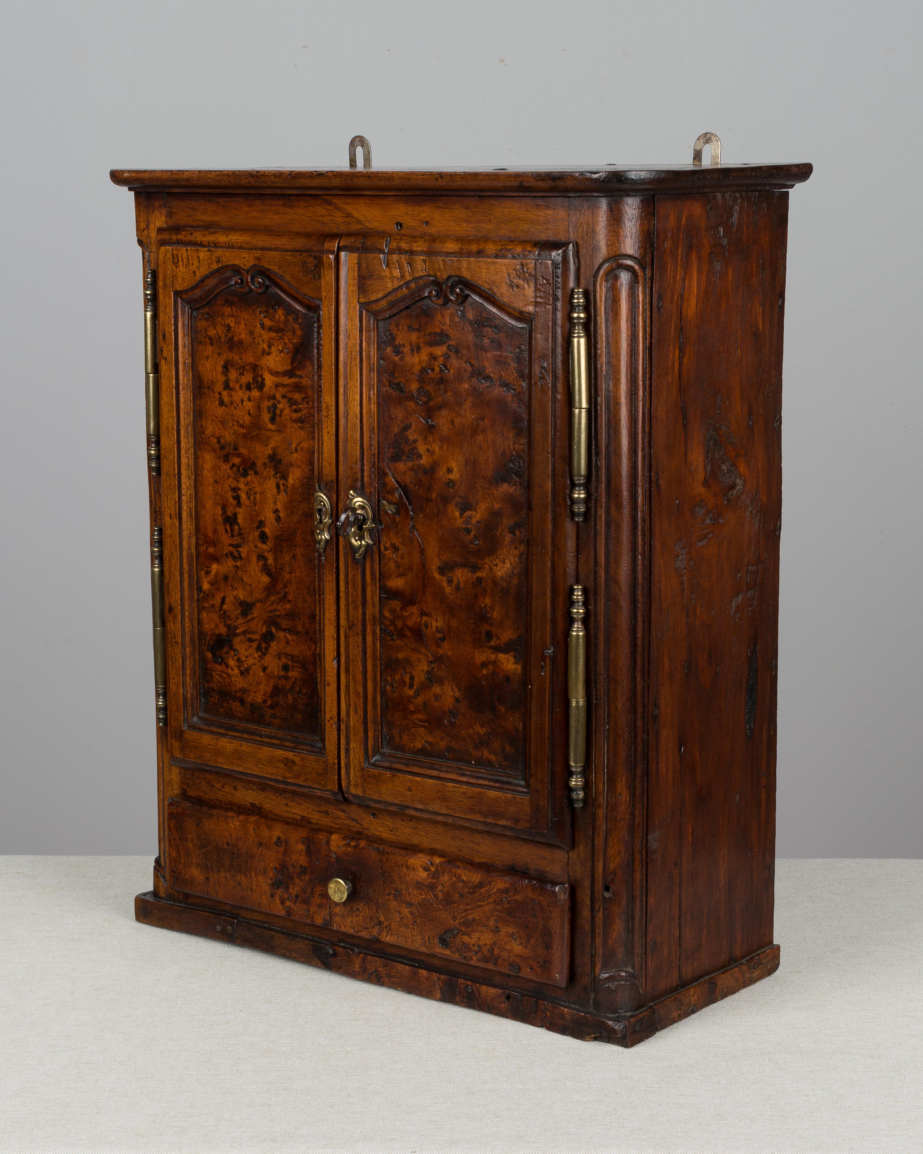 Une armoire d'échantillons miniatures de style provincial français du 18ème siècle provenant de la région de Bourgogne. Fabriqué en noyer et en loupe de chêne avec du pin comme bois secondaire. Une armoire ancienne rare, joliment ouvragée avec de