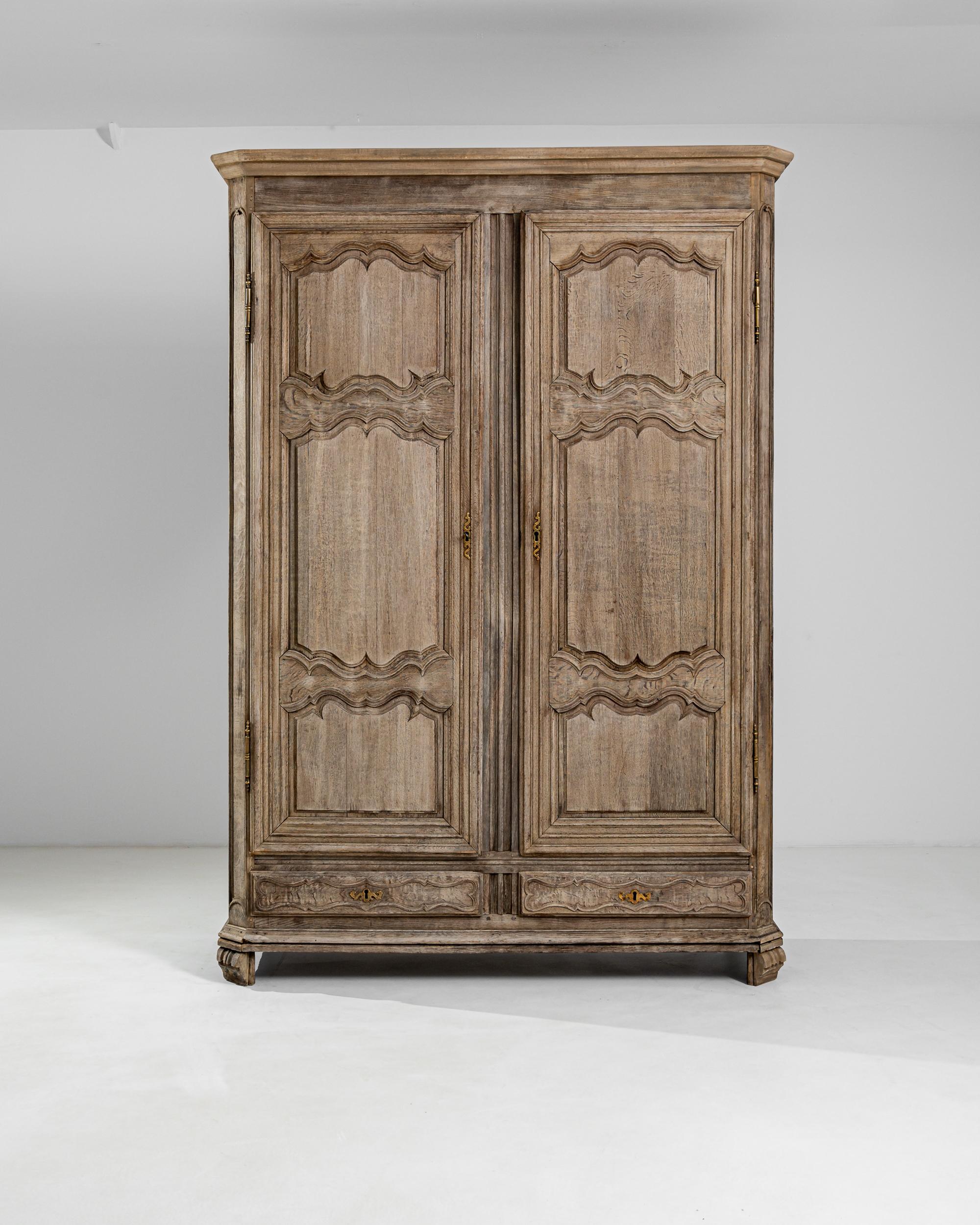 Une magnifique ébénisterie et des proportions statuaires confèrent à cette armoire en chêne ancien une présence captivante. À l'époque de sa construction, au XVIIIe siècle en France, un tel mobilier aurait été un luxe peu commun - cette pièce aurait