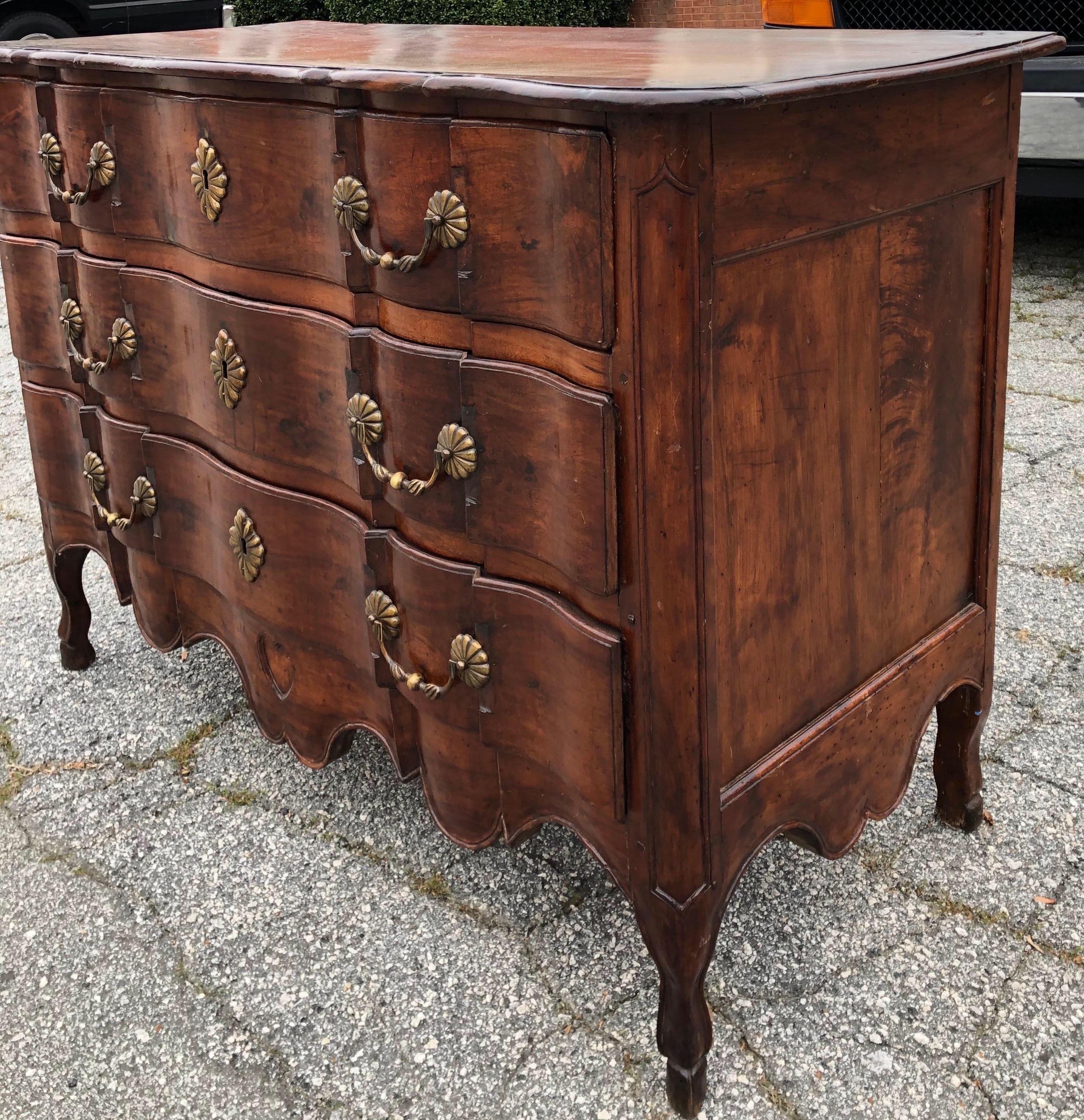 18th century French Provincial walnut 3-drawer commode with hoof feet, heart carved apron and shaped top. Gorgeous patina. Old charming repair to the front left corner of the top- see photos.