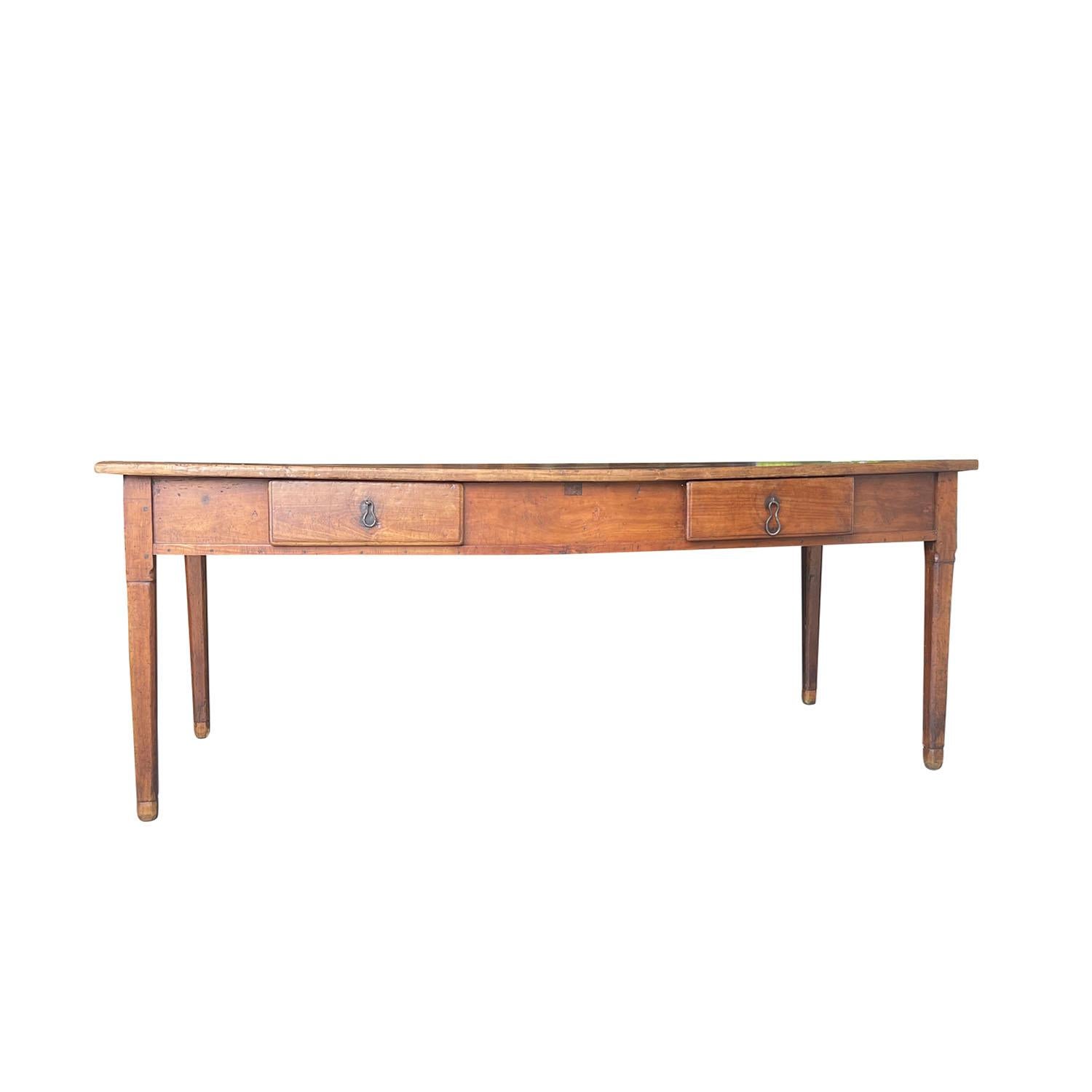 Une table de salle à manger ancienne de style provincial français de la fin du XVIIIe siècle, en noyer travaillé à la main, en bon état. La table de ferme rectangulaire et rustique est composée de deux tiroirs, rehaussés de leur quincaillerie