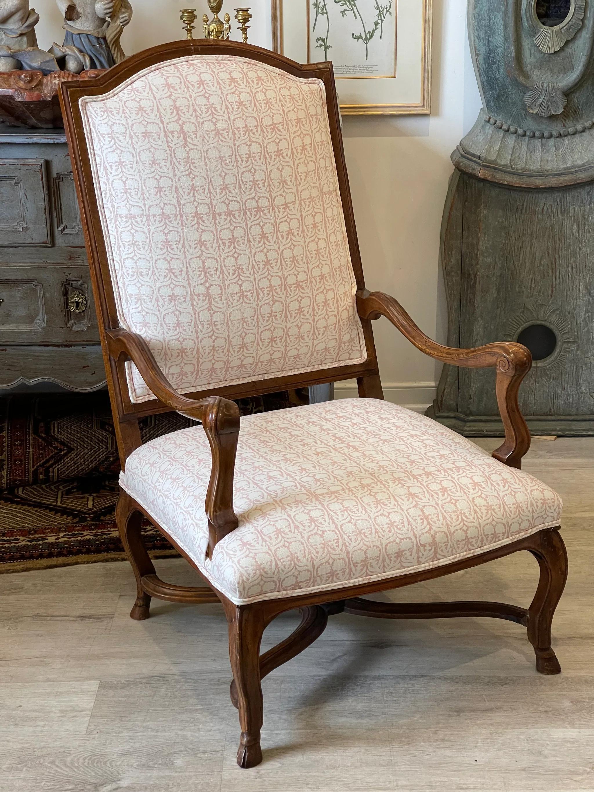 French Provincial Walnut Fauteuil a la Reine, arm chair, 18th century, with an arched back crest, down-swept arms and raised on cabriole legs ending in hoof feet, of pegged construction. Upholstered in hand-blocked fabric by Penny Morrison.
