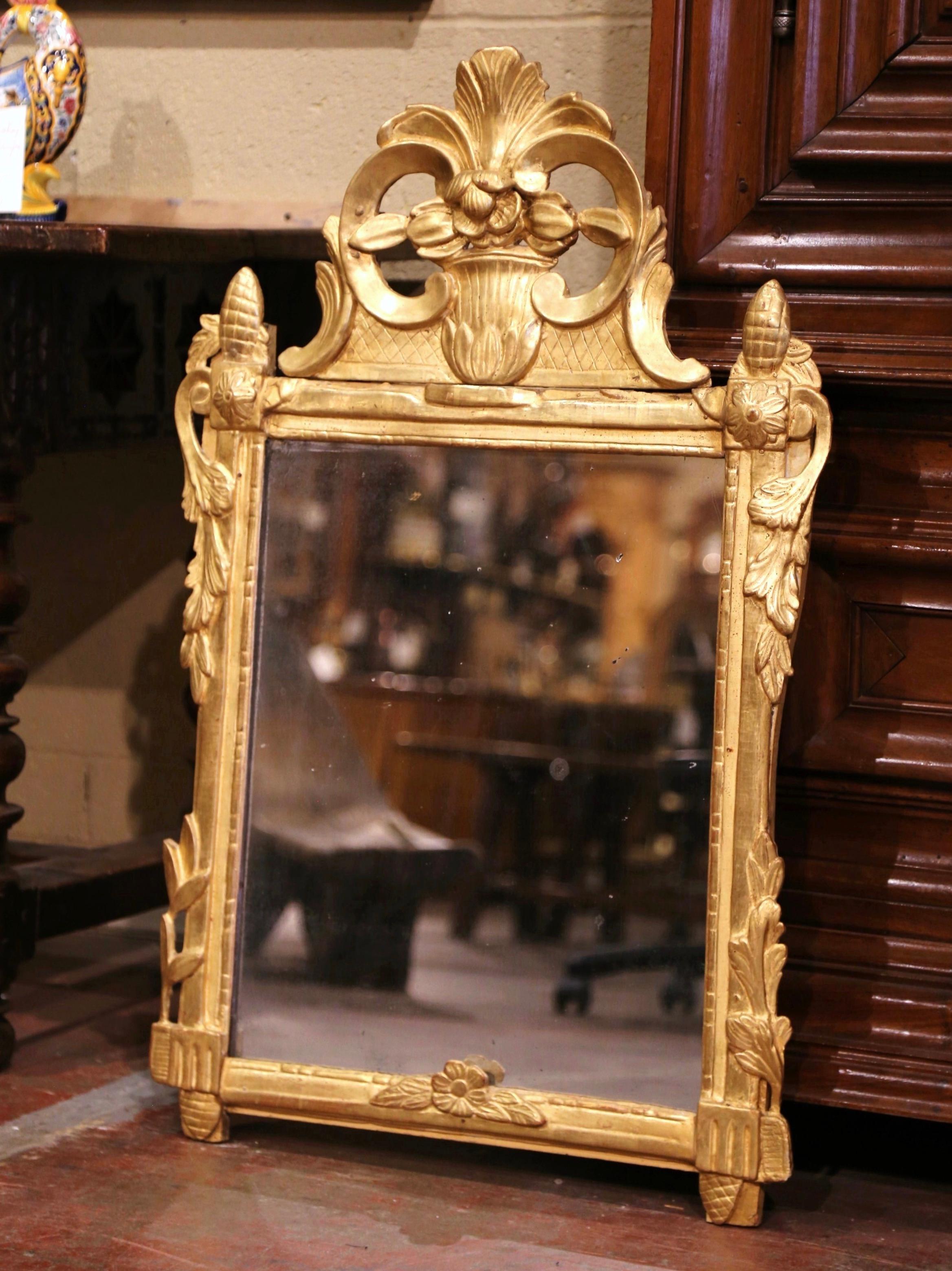 This elegant, antique gilt mirror would make a charming addition to an entryway or powder room. Crafted in Southern France, circa 1780, the rectangular Provincial mirror is heavily carved and exemplifies the design elements of the Rococo and Baroque