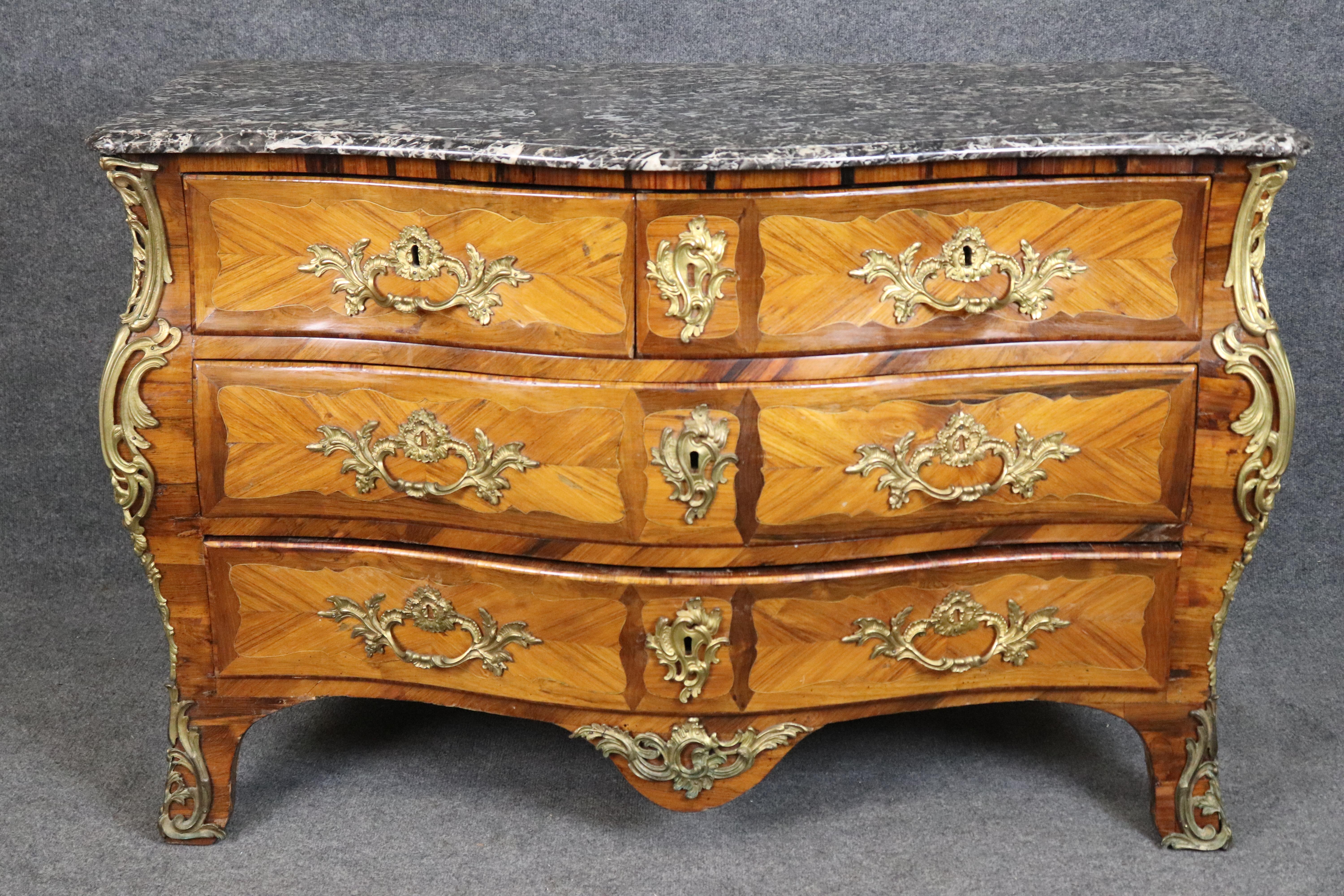 This exquisite French Louis XV bronze-mounted commode is attributed to Louis Pelletier, one of the distinguished 18th-century ébénistes of Paris. With its serpentine front, bombe sides, and intricate parquetry veneer, this commode epitomizes the