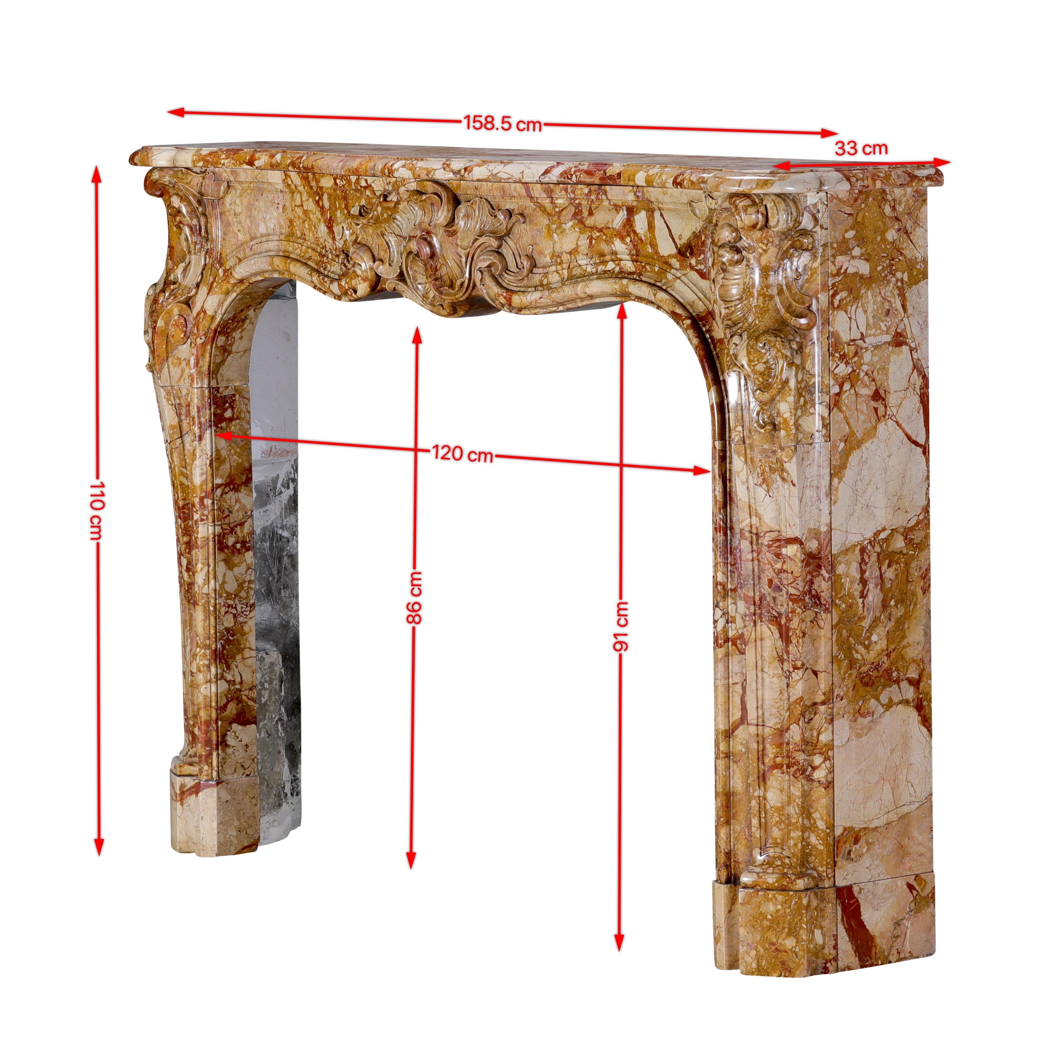 Este auténtico marco de chimenea rococó de la Regencia francesa del siglo XVIII es un espléndido ejemplo de artesanía de influencia palladiana, esculpido en un raro mármol real, ricamente coloreado con intrincadas vetas de ámbar, ocre, marfil y
