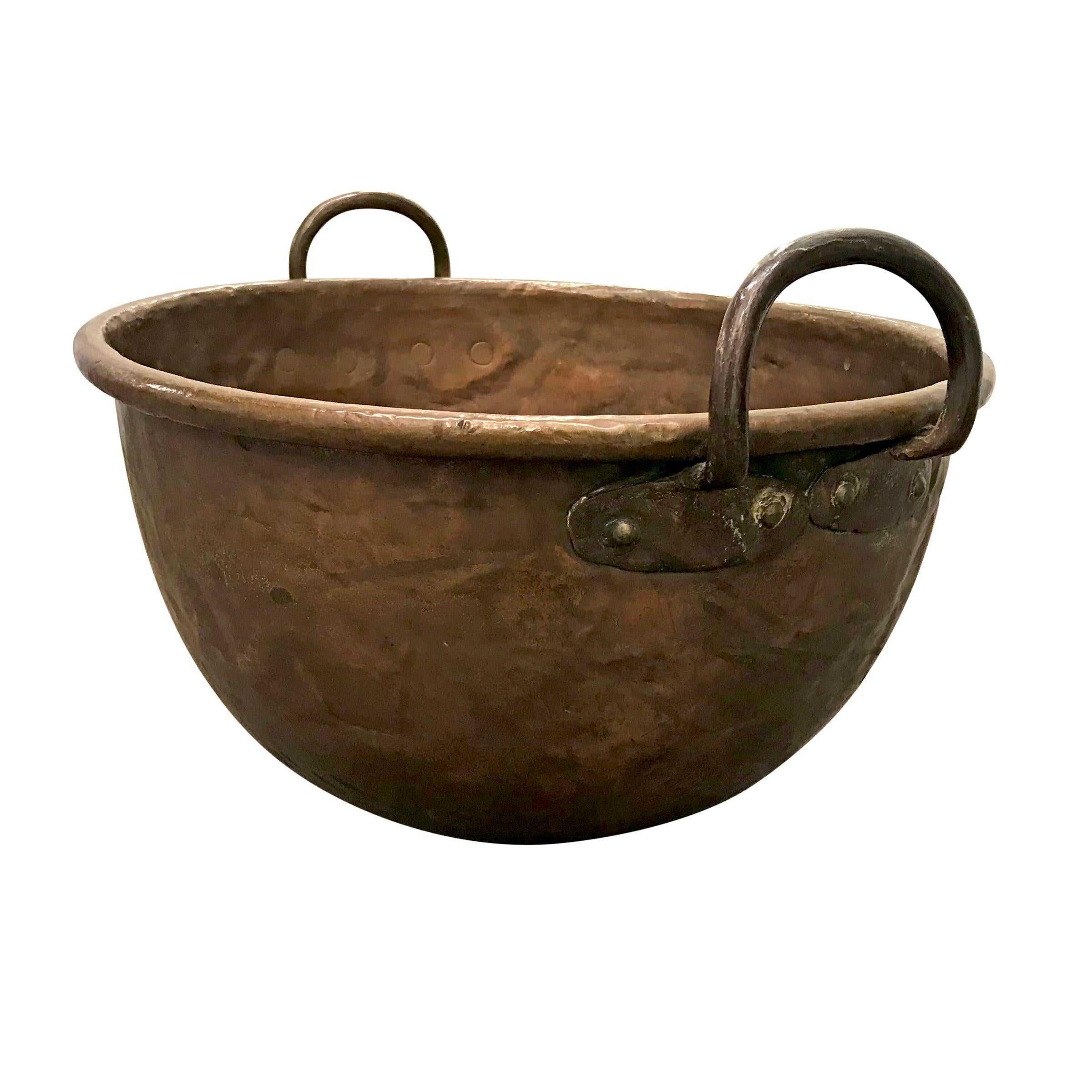An 18th century French copper confectioner's pot with wonderfully forged handles, a thick rolled rim, and a circular patch at the bottom with the most elaborate hand-hammered rivets. We think this is great as is, or it could be turned into a sweet