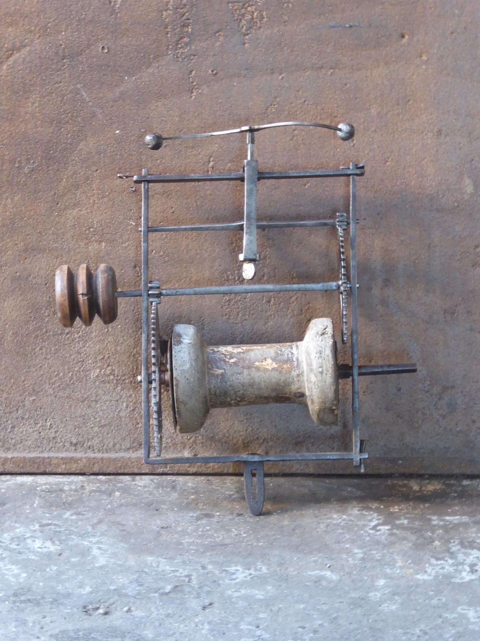 Early 17th century French weight-driven spit jack made of wrought iron, wood and lead. It was used for cooking in a kitchen fireplace. The forged frame is held together with wedges, a very old technique. The mechanism is still functional, though it