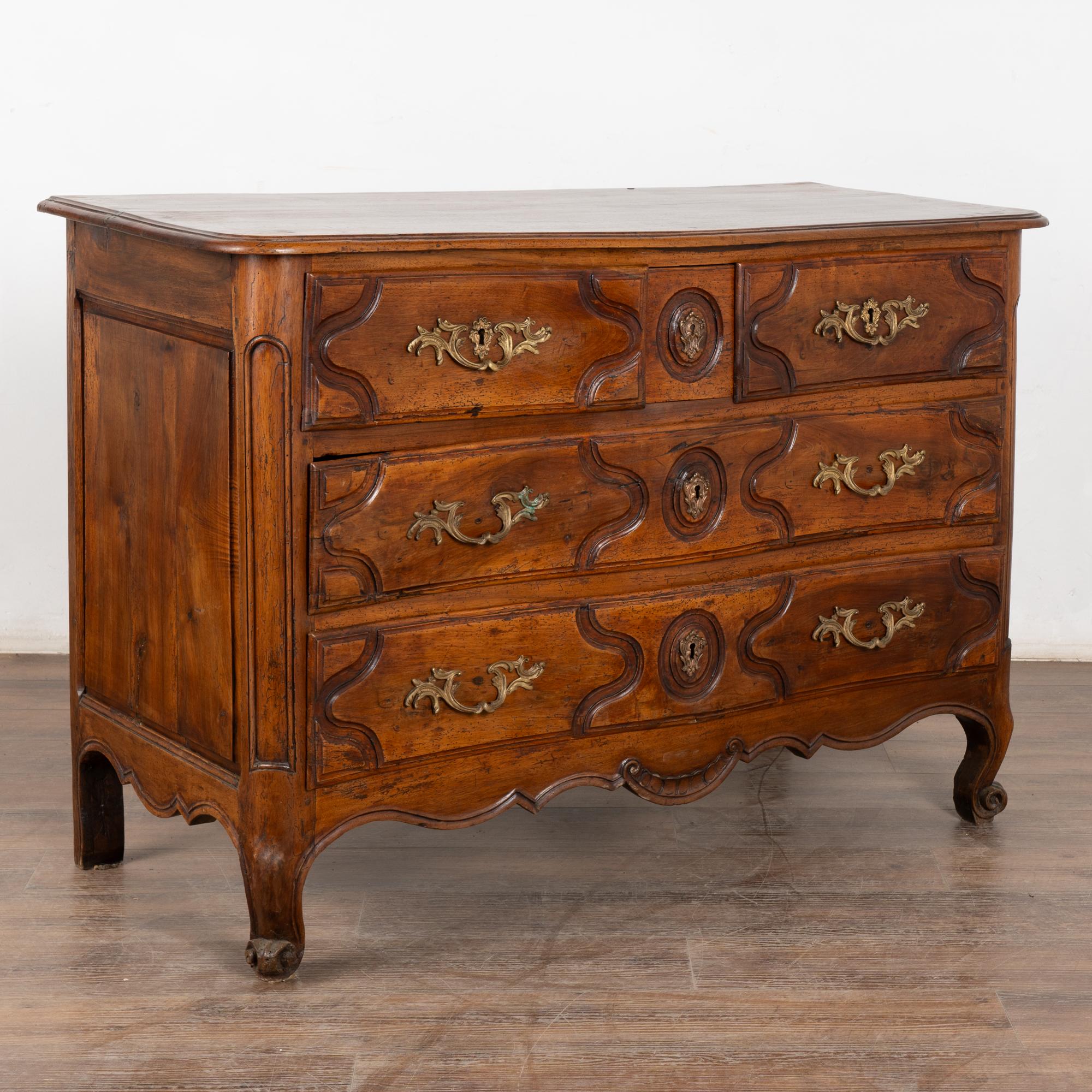 Commodo a quattro cassetti in noce rococò francese con pannelli e gonna intagliati, poggiante su piedi intagliati.
Grande cassetto in ottone e chiave in noce rococò francese a quattro cassetti con pannelli e gonna intagliati, poggiante su piedi