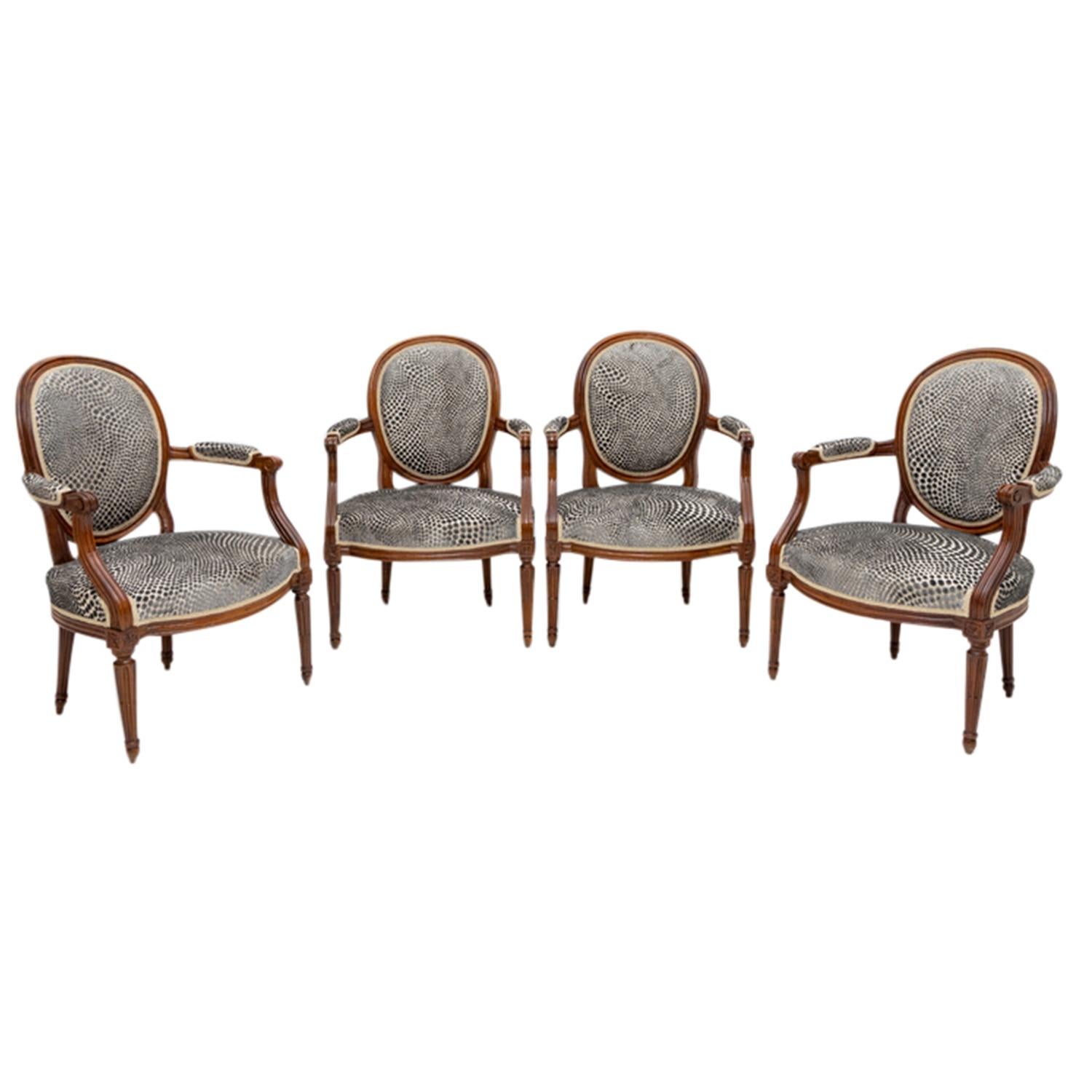 A late 18th Century, antique French set of four Medallion dining room armchairs made of hand crafted polished, lacquered Beechwood in good condition. The Parisian polished cocktail chairs have an inclined backrest, detailed with slim upholstered