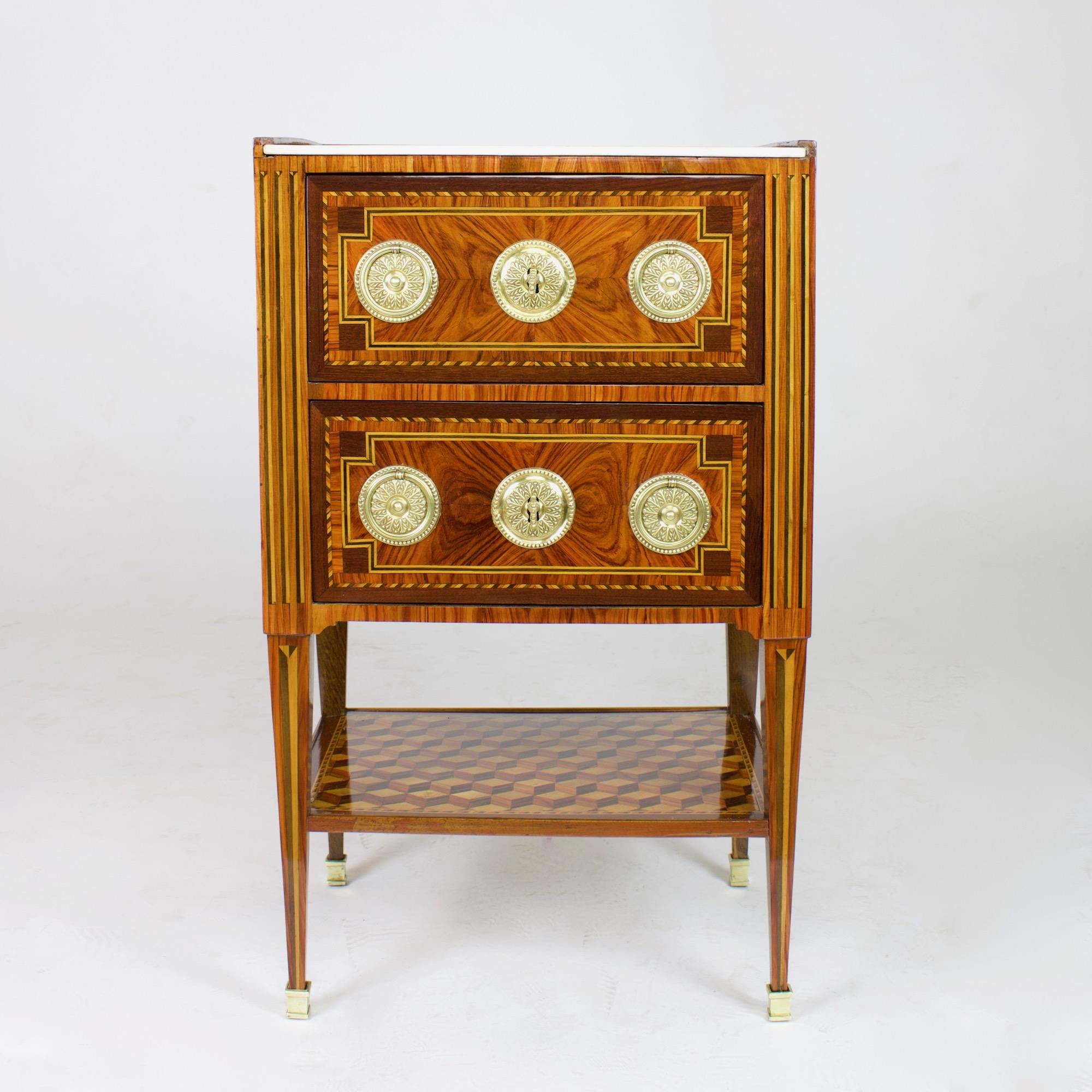 Excellent small Louis XVI period table, so-called “table chiffoniere”, made ca. 1775 in Eastern France, probably Strasburg: 

A rectangular side table standing on square tapering feet with trompe l’oeil fluting marquetry and gilt bronze sabots