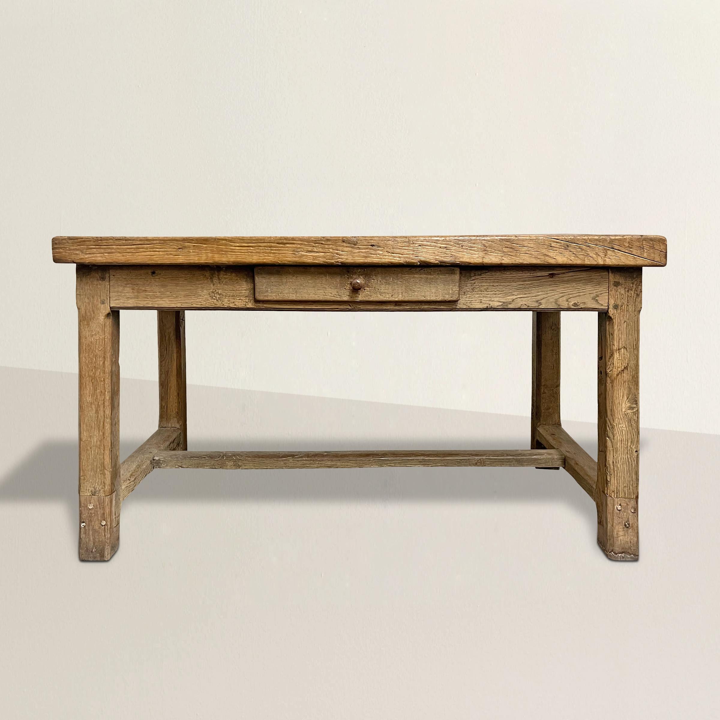 An incredible 18th century French Provincial oak work table from Normandy with a 2.5 inch thick top supported by chamfered square legs, a well-worn stretcher, a single drawer on one side, and the most beautiful finish we've seen in a long time. The