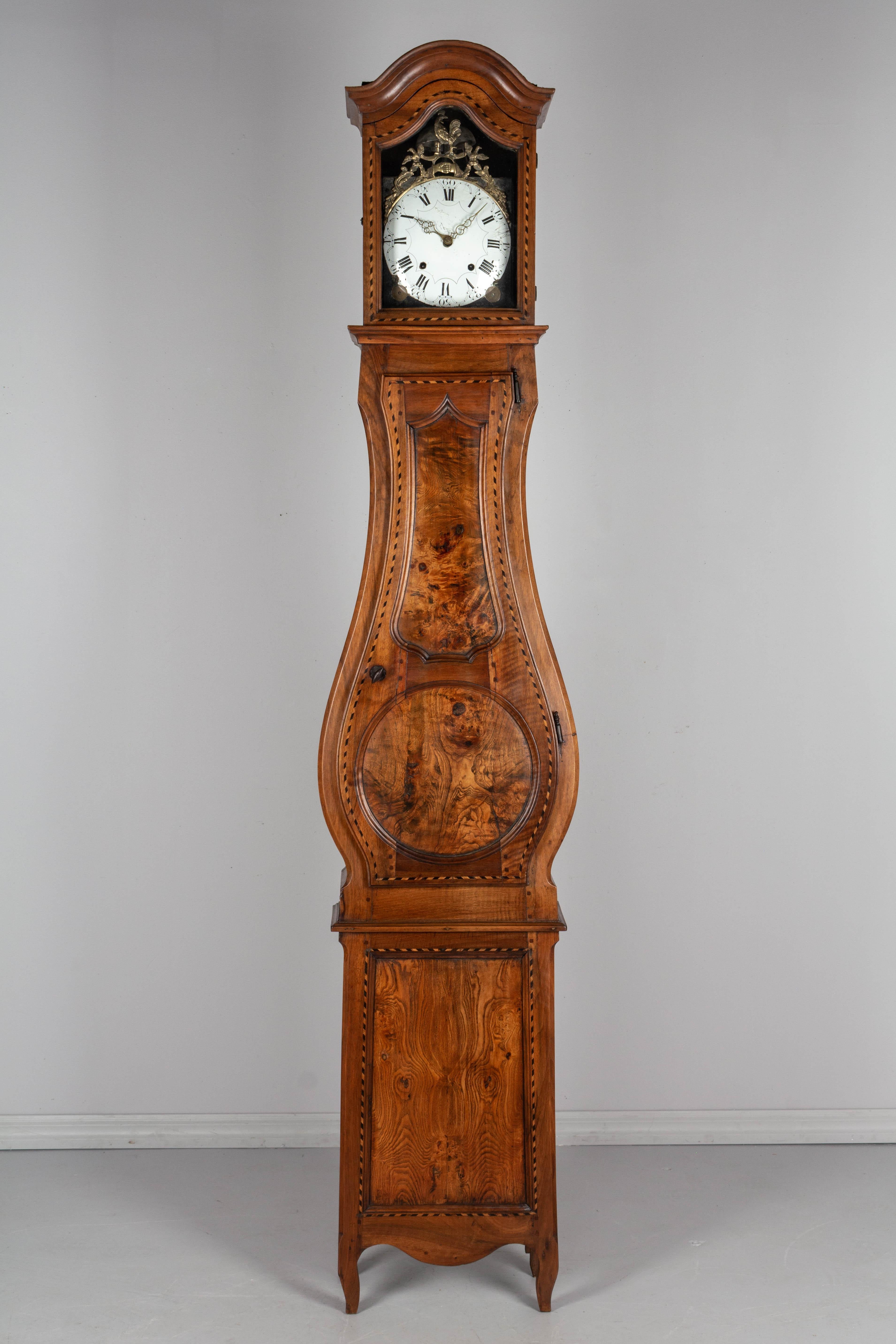 An exceptional 18th century French Horloge De Parquet, or tall case clock, from Pays de Bresse in Burgundy. The case is made of solid walnut with bookmatched wood at the base and a door with inset panels of beautiful burled elm. In two parts: the