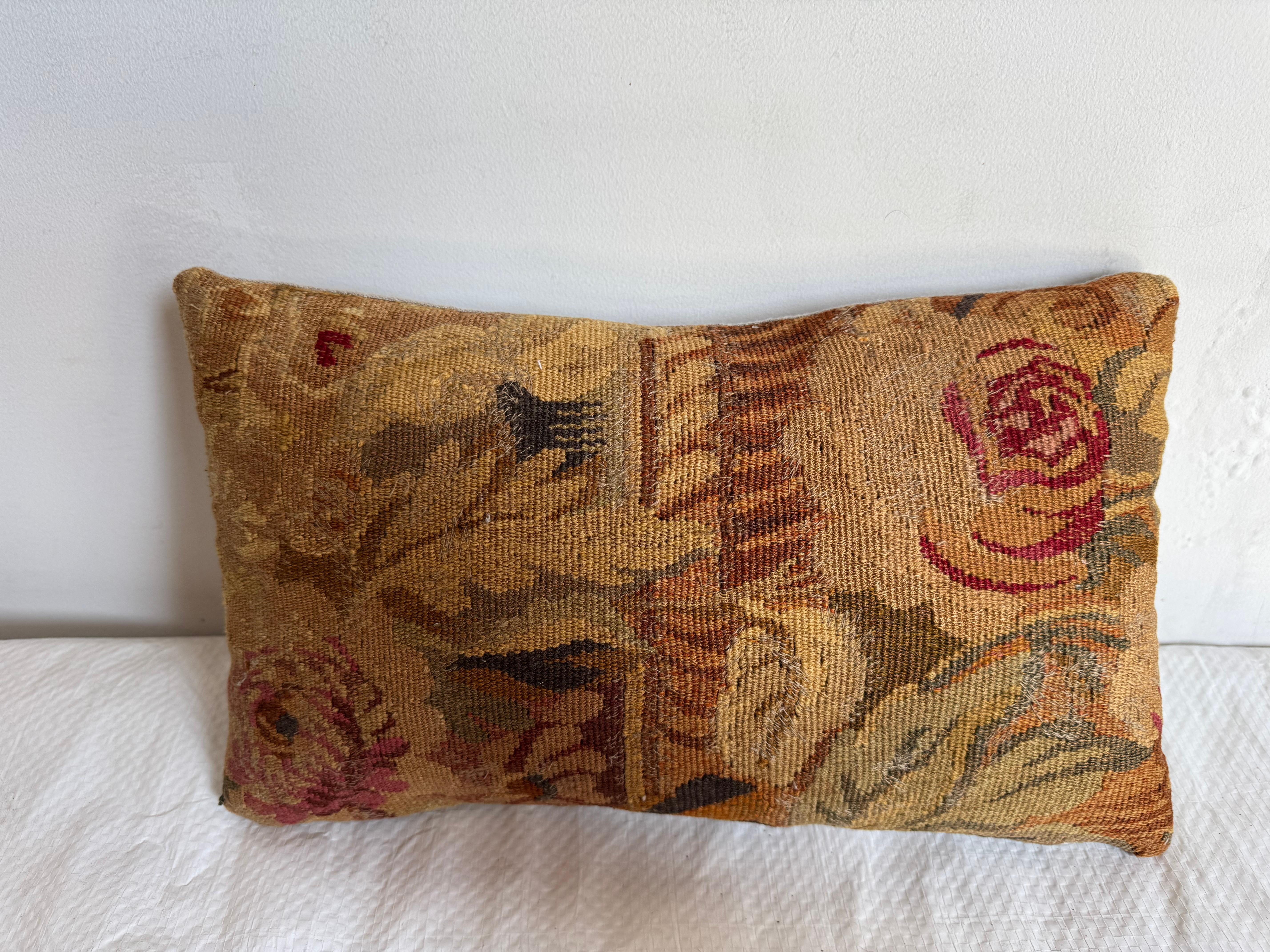 Se trata de un cojín tapiz de estilo auténtico Aubusson, que muestra la refinada elegancia de la artesanía francesa del siglo XVIII. Tejida con maestría en una técnica de tejido plano, la almohada presenta un romántico diseño floral con rosas y