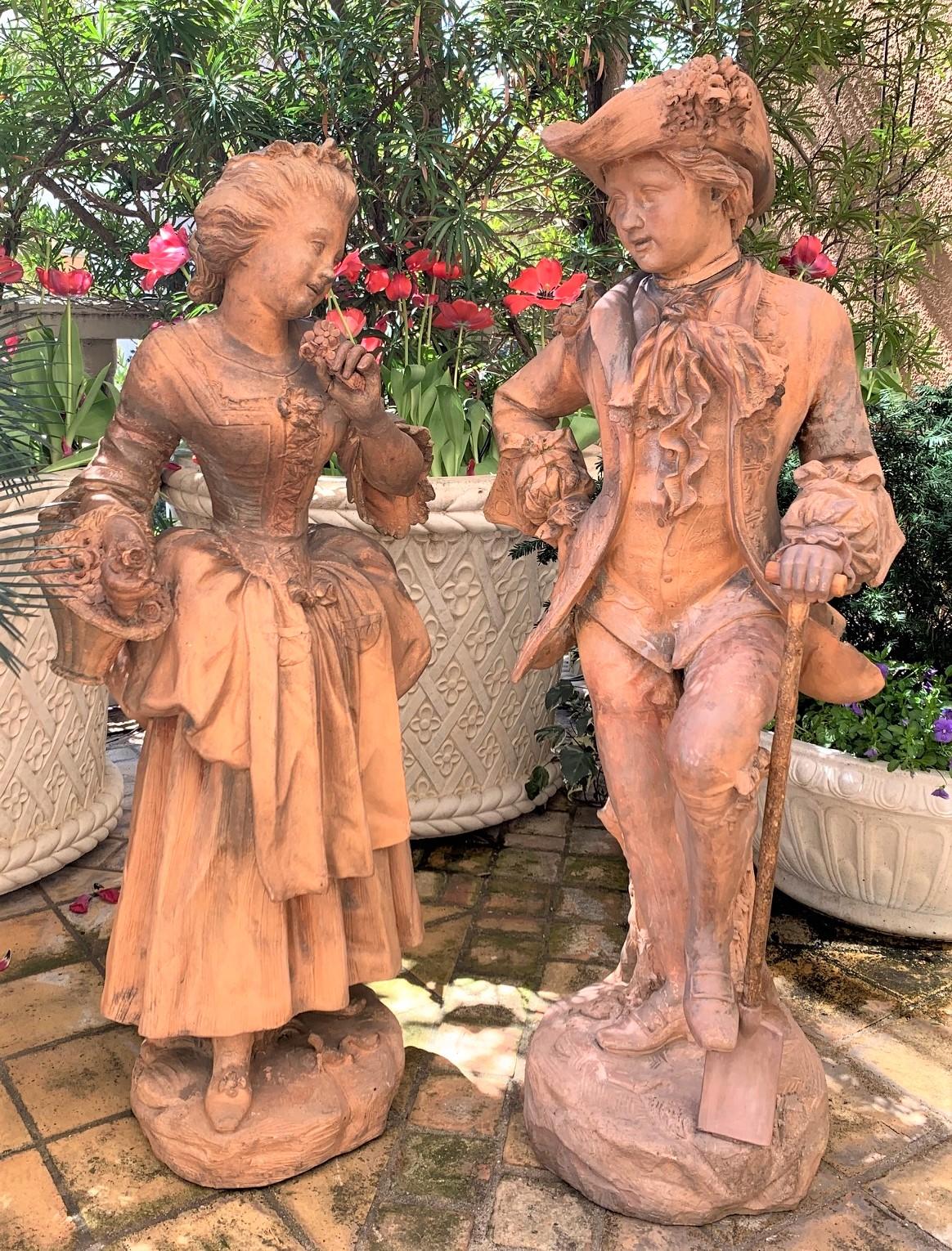 Important pair of 18th century French terracotta sculptures of a young lady and gent dressed in formal attire of the period. The lady holds a basket of flowers, the gent with a digging spade. Phenomenal detail overall with life-like expression.
