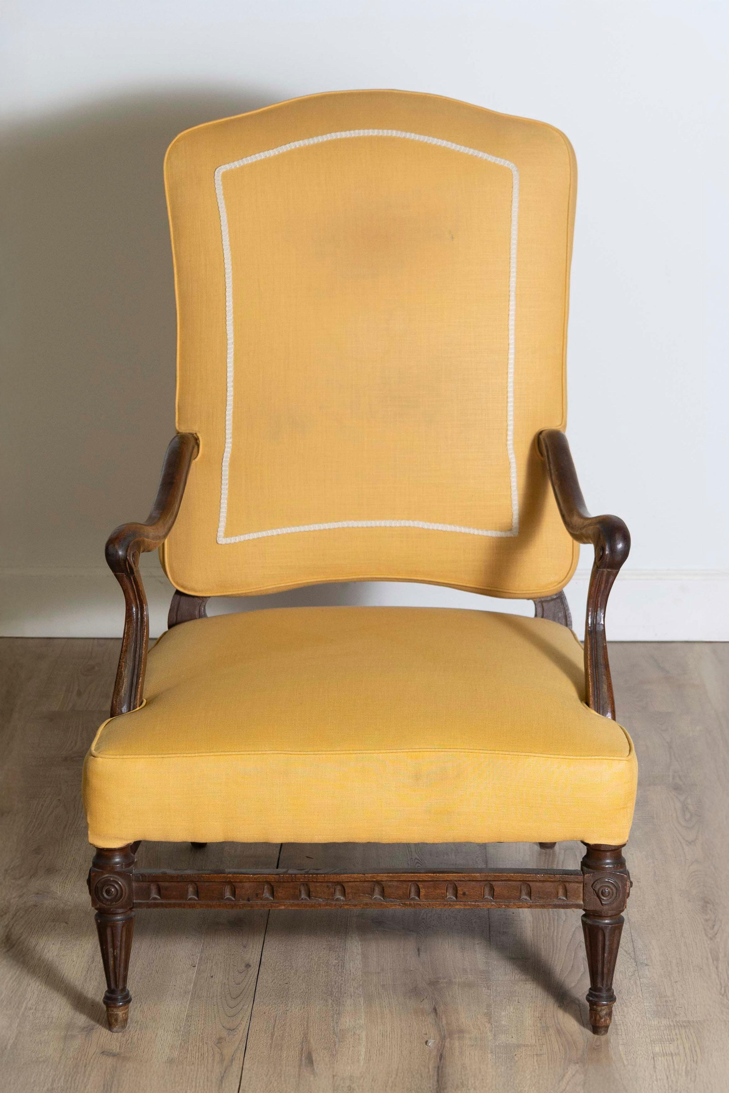 Fauteuil d'époque Transition en noyer français du XVIIIe siècle, avec des accoudoirs à enroulement, des pieds fuselés cannelés et des brancards sculptés. Fauteuil d'époque Transition en noyer français du XVIIIe siècle, incarnant la transition