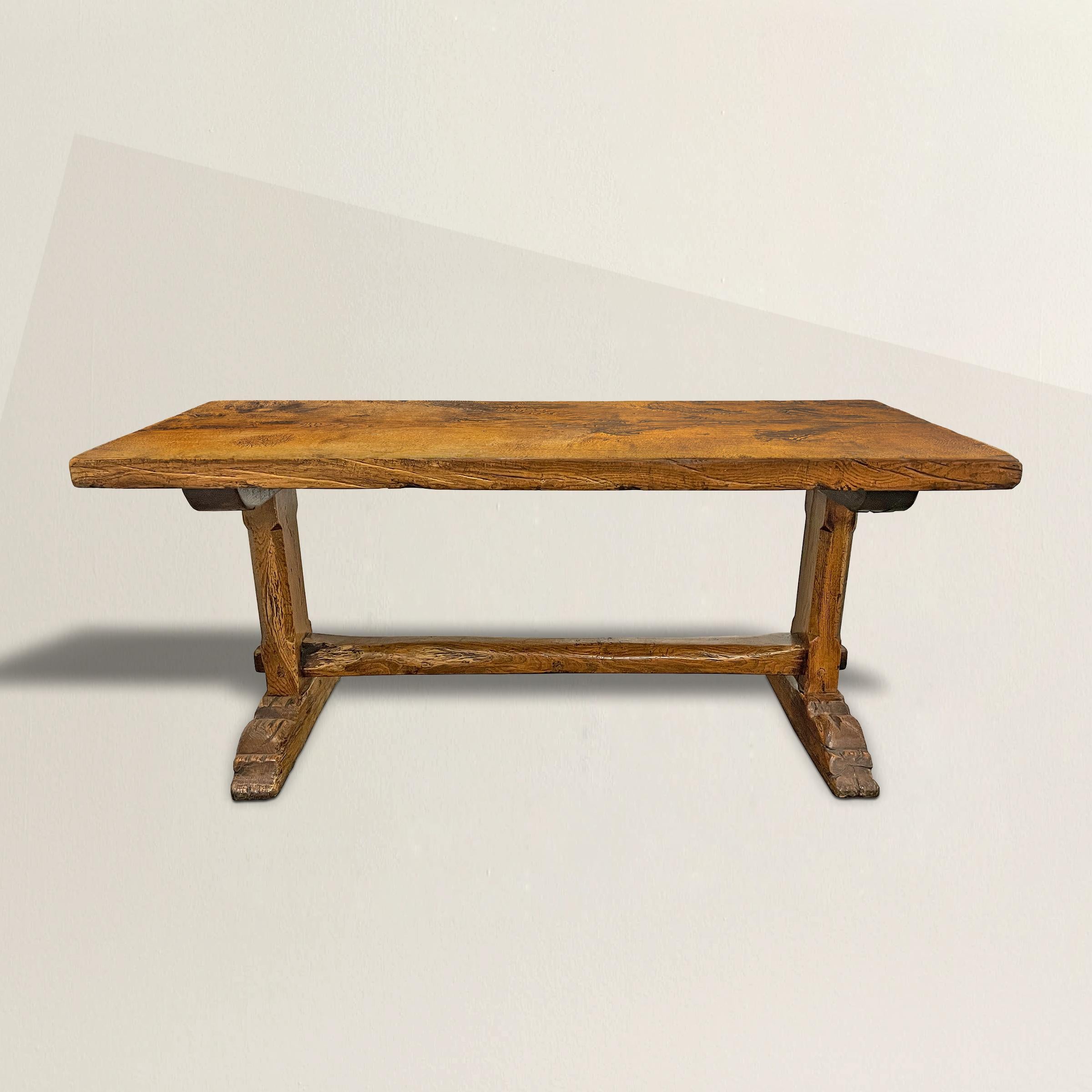 The best early 18th century French oak trestle table with a three-inch thick hand-hewn single-plank top resting on a hand-carved trestle base with chamfered legs and well-worn feet. The finish is the most beautiful we've seen in a long time, with a