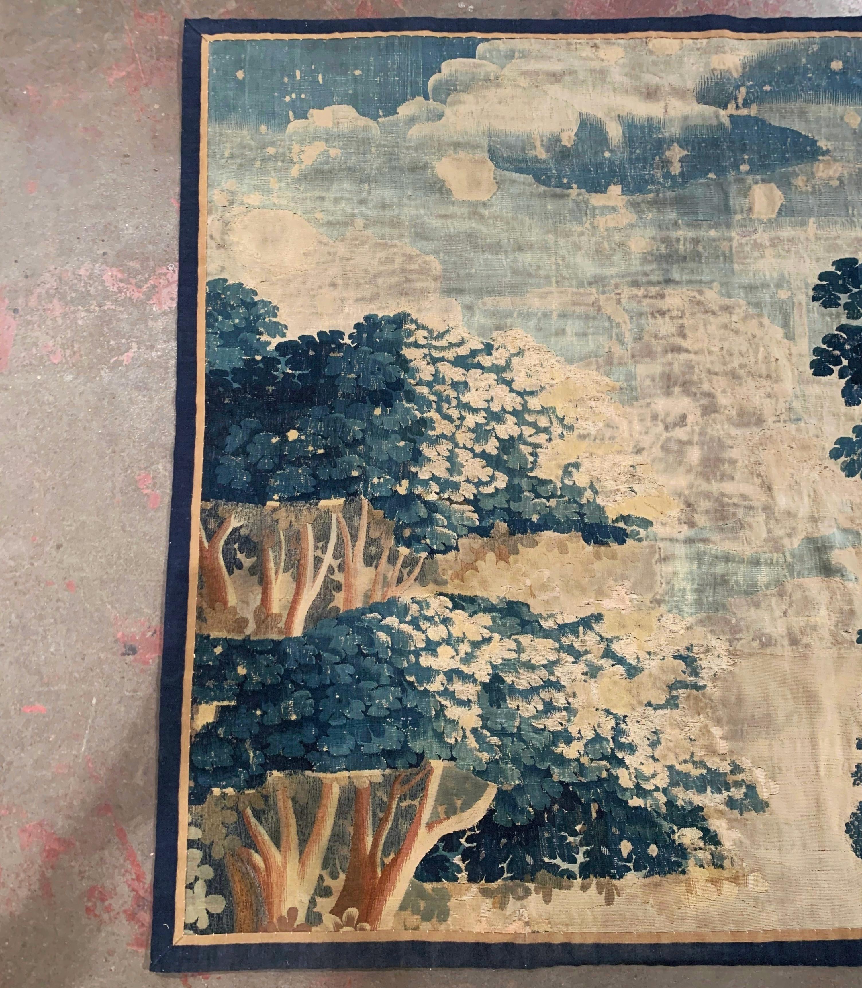 This antique tapestry was woven in Aubusson, France, circa 1750. The colorful verdure wall hanging piece features trees and leaves in the blue, green and beige palette. The wall piece is in good condition with wear commensurate with age and use. The